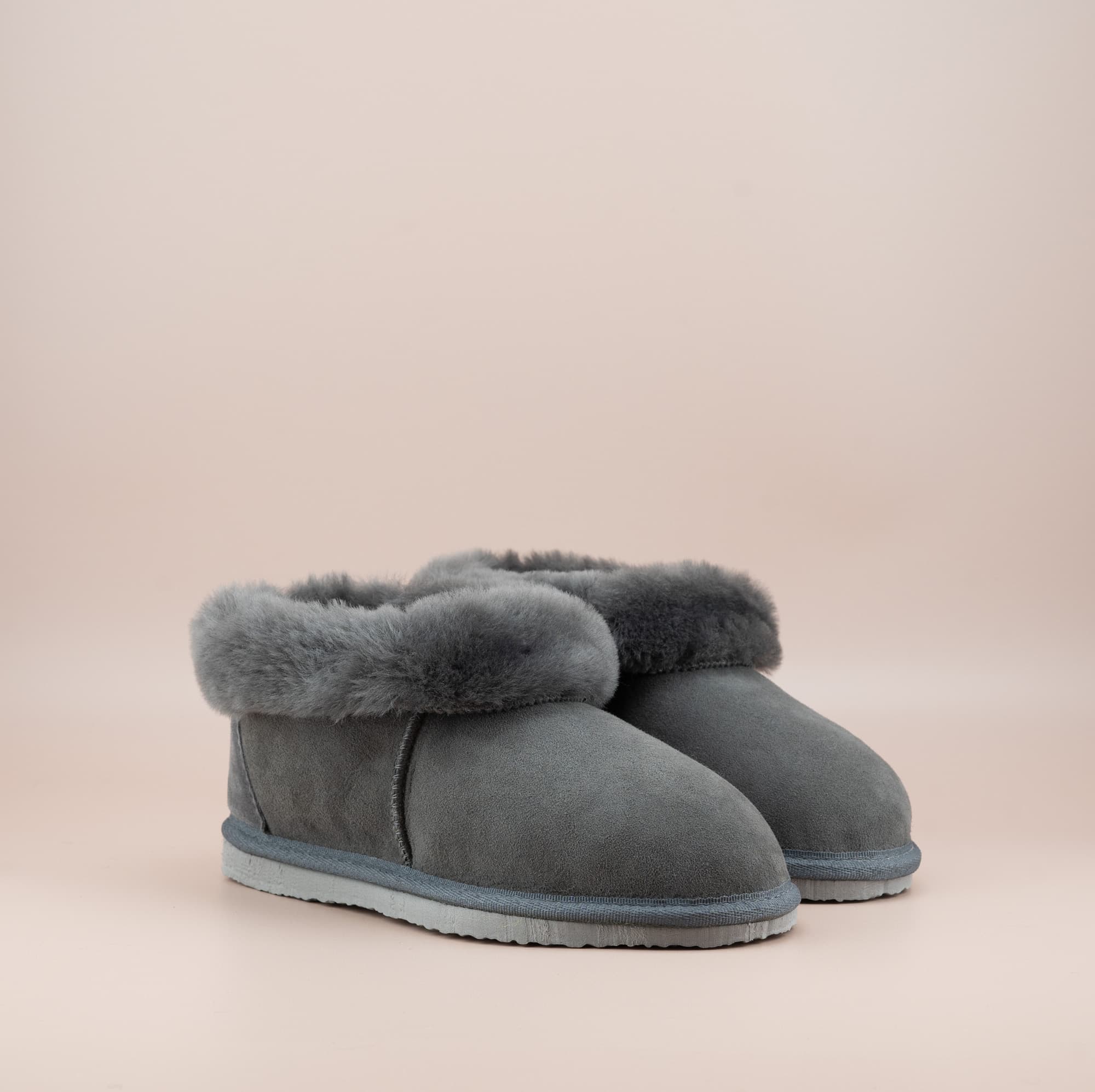 Men's ugg slippers with a suede finish in grey and wool turn, side view of the pair. #color_grey