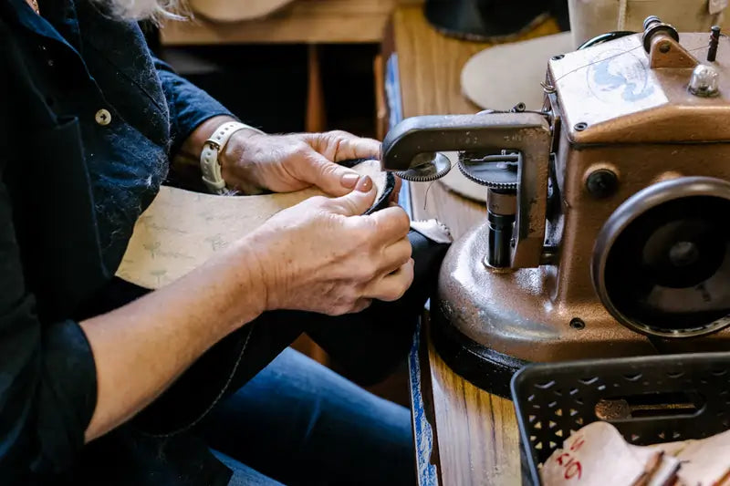 Jassi worker sewing an ugg boot by hand with an overlocker.