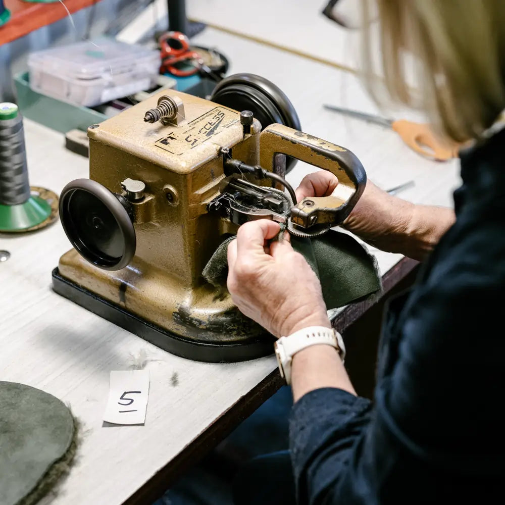 Jassi worker stitching two pieces of genuine australian sheepskin together to make an ugg boot.,