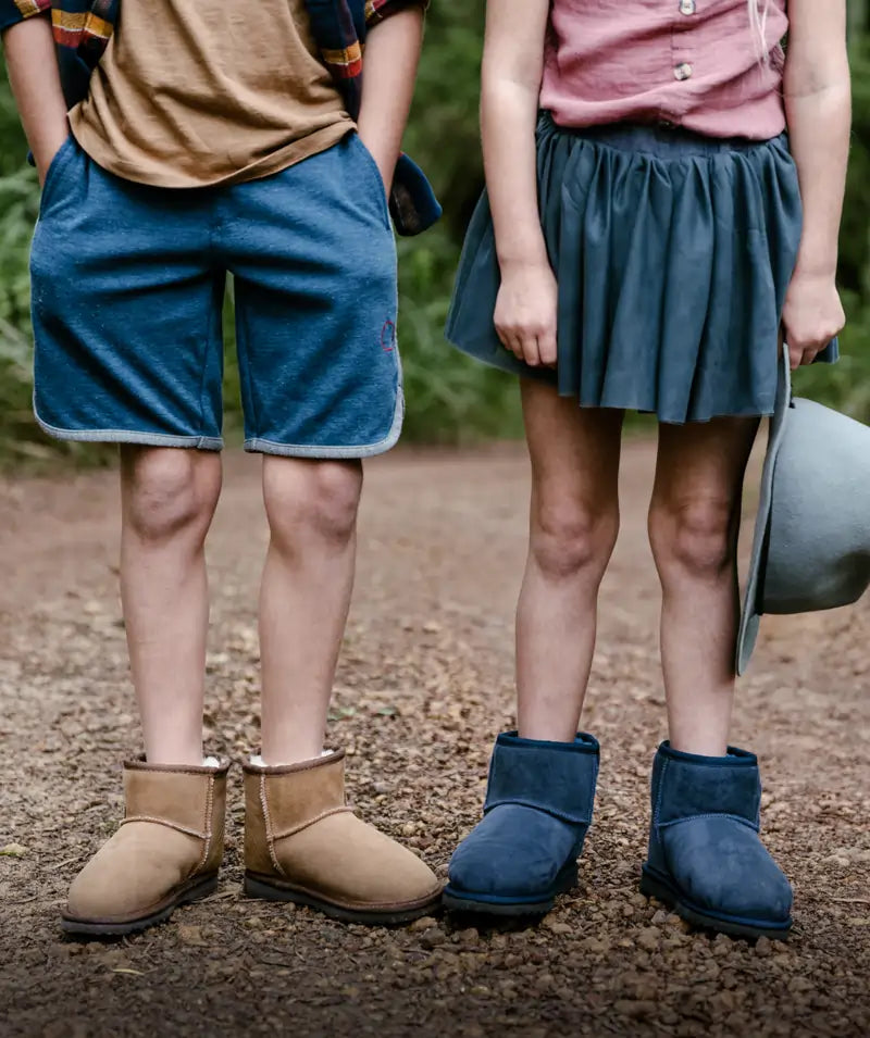 Kids outdoor wearing Jassi short suede  ugg boots in tan and navy.