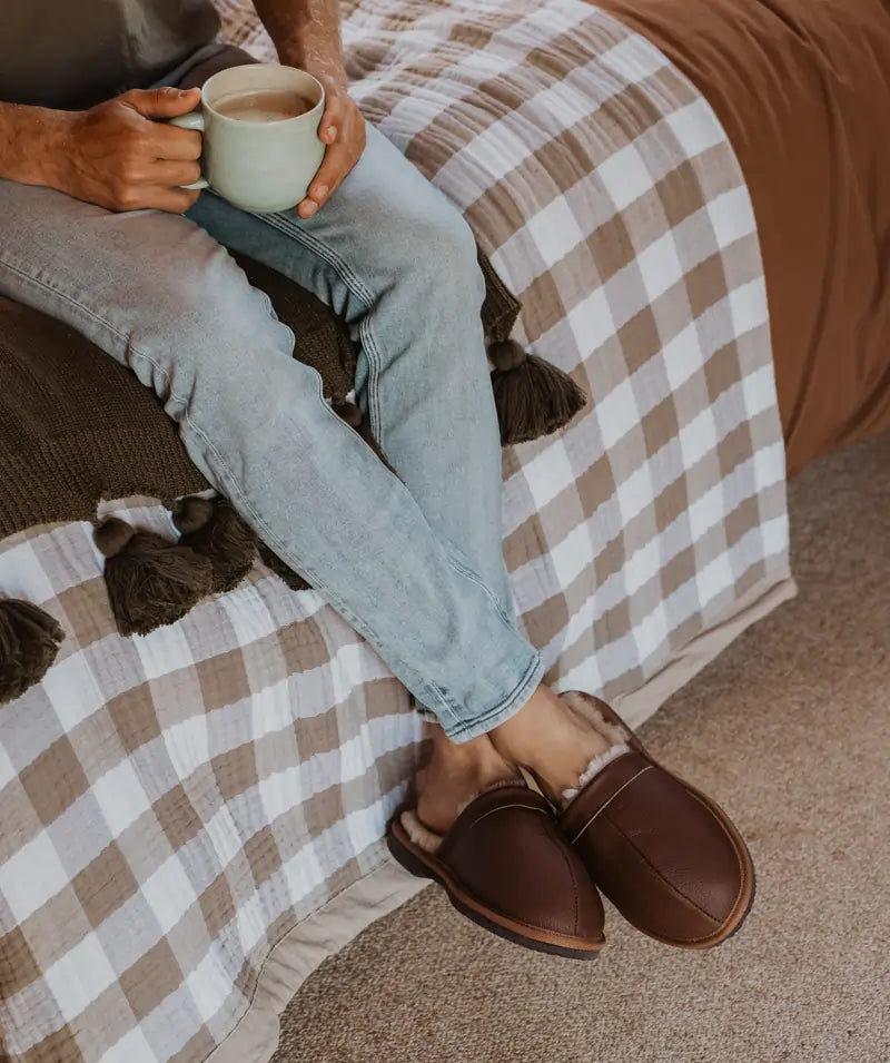 Man enjoying a tea while earing comfy jassi leather scuffs in tan.