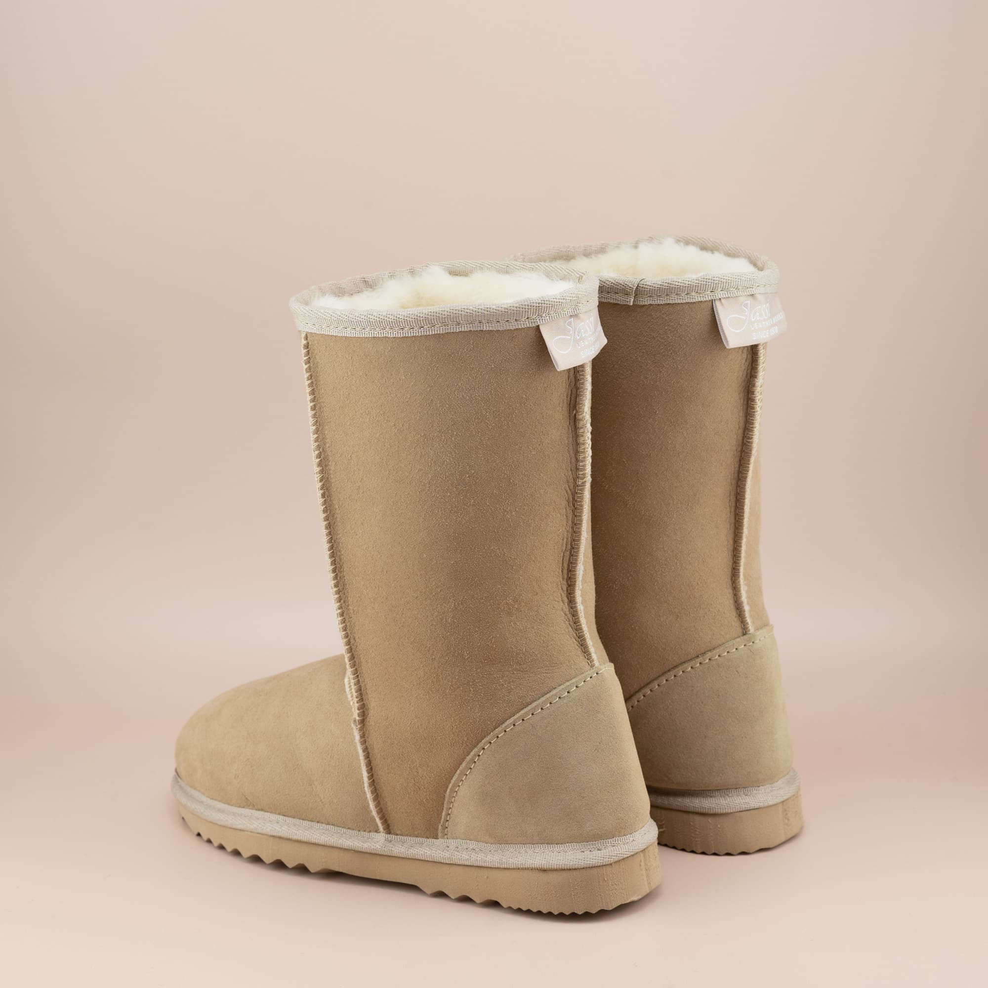 Kid's classic mid ugg boot in suede sand color, back view. #color_sand