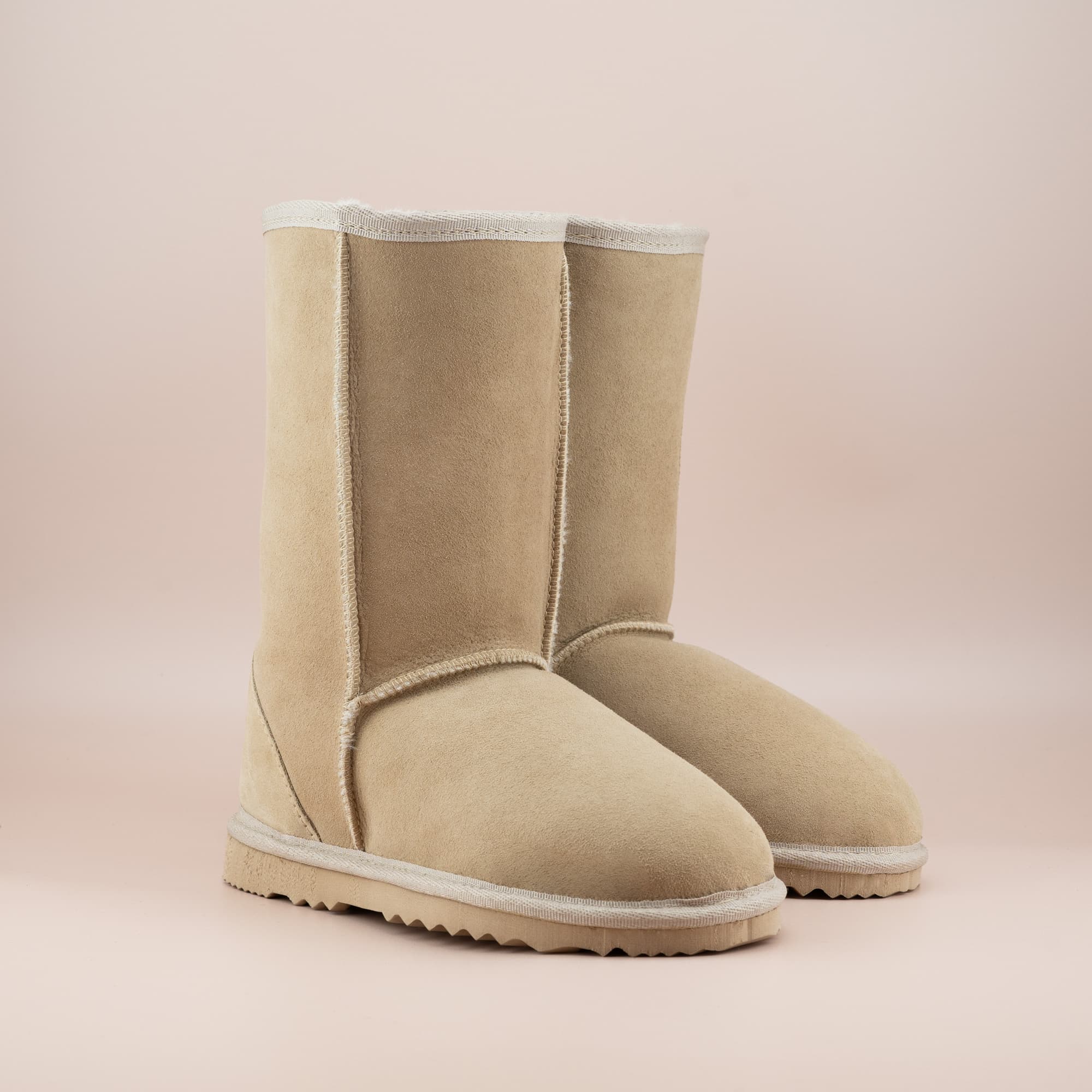 Kid's classic mid ugg boot in suede sand color, front side view. #color_sand