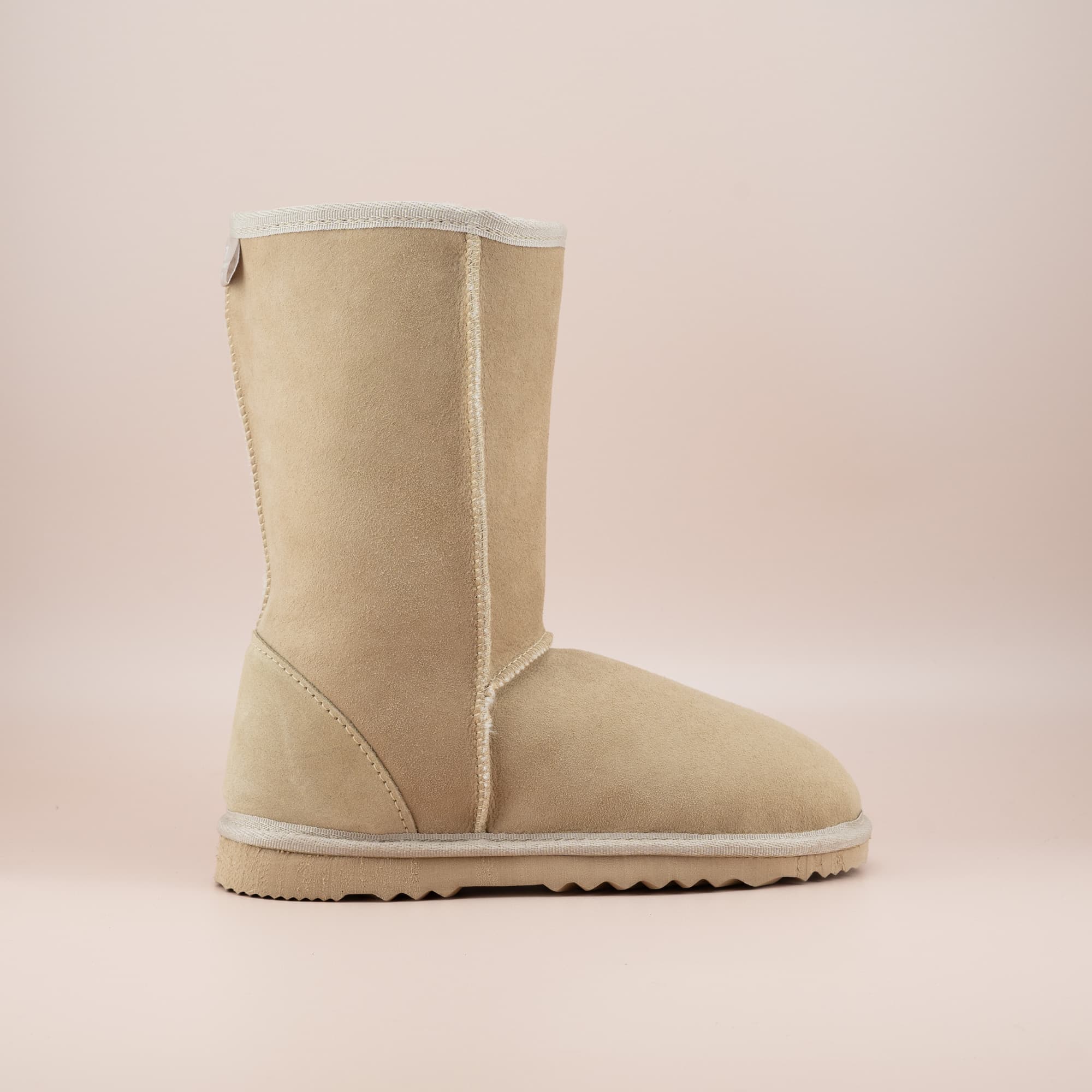 Kid's classic mid ugg boot in suede sand color, side view. #color_sand