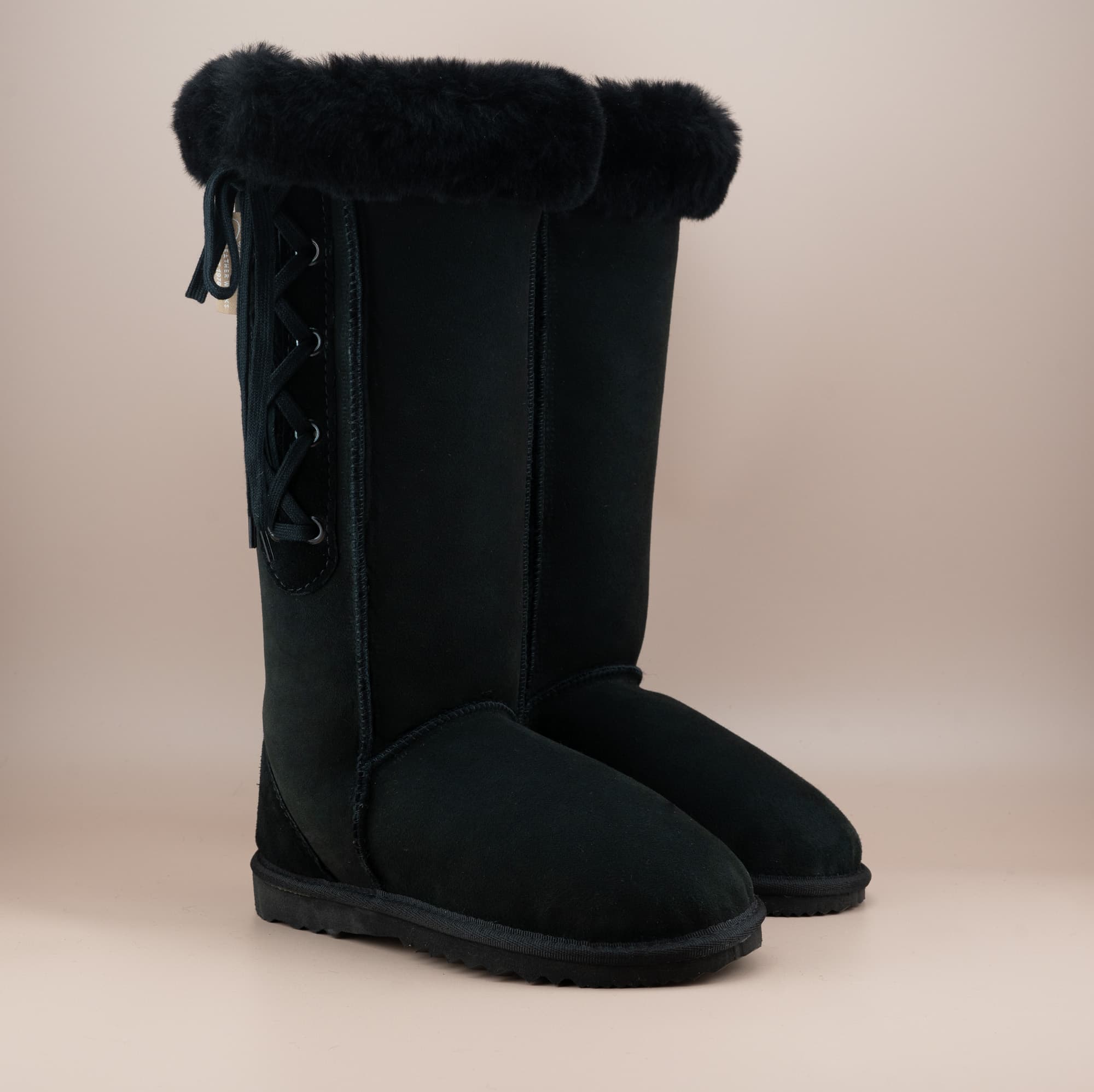 Men's long lace-up ugg boot in color black and soft suede finish with signature wool turn, front side view. #color_black