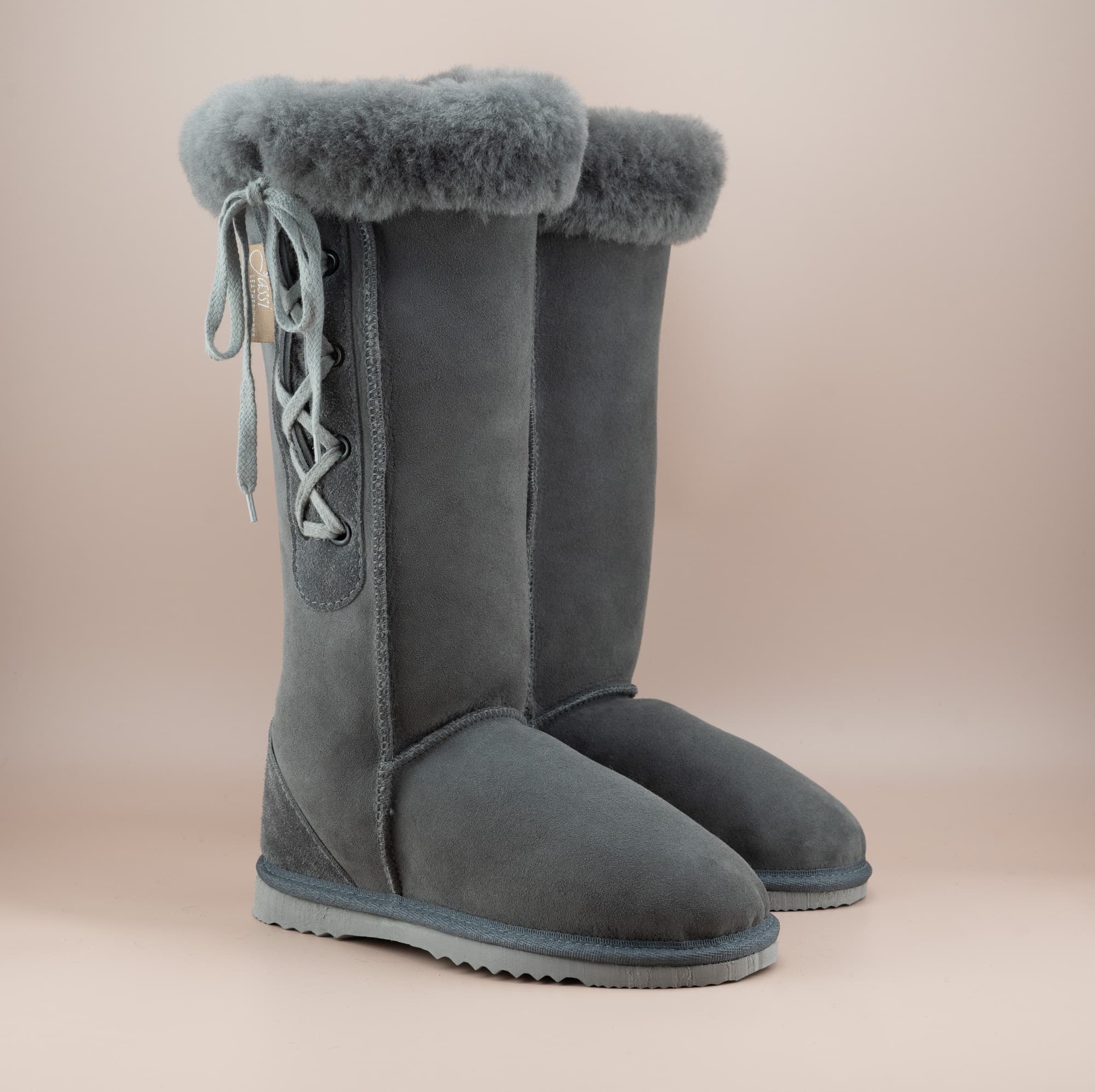 Men's long lace-up ugg boot in color grey and soft suede finish with signature wool turn, front side view. #color_grey