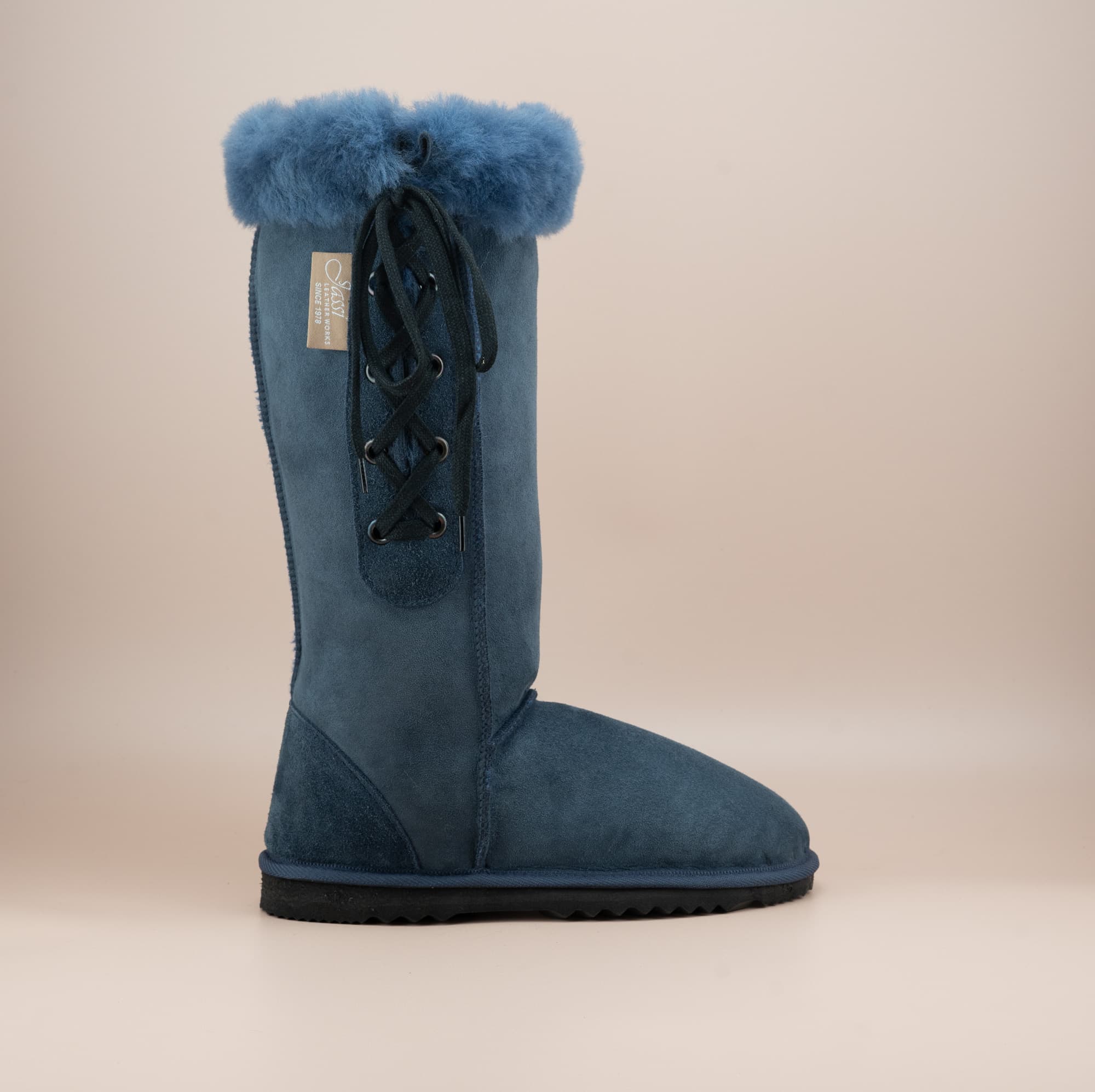 Men's long lace-up ugg boot in color navy and soft suede finish with signature wool turn, side view. #color_navy