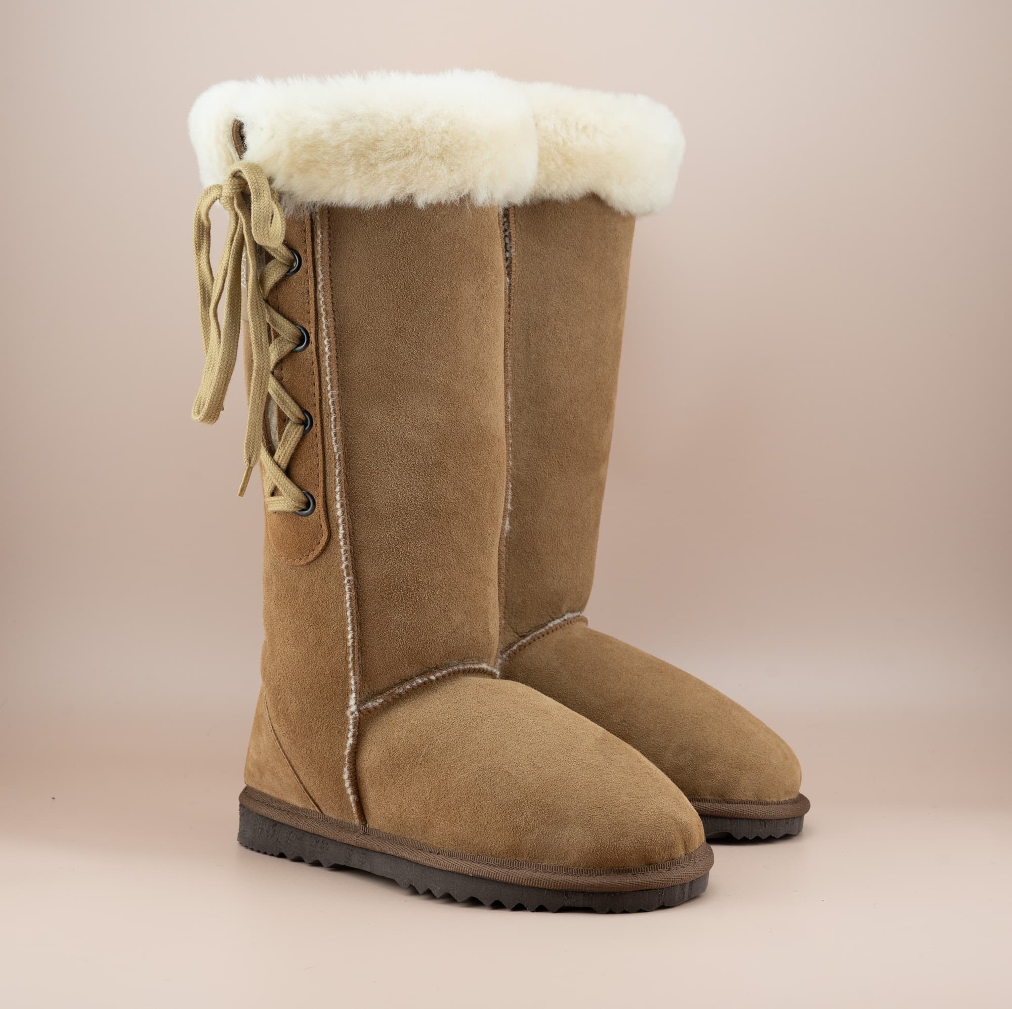 Men's long lace-up ugg boot in color tan and soft suede finish with signature wool turn, front side view. #color_tan