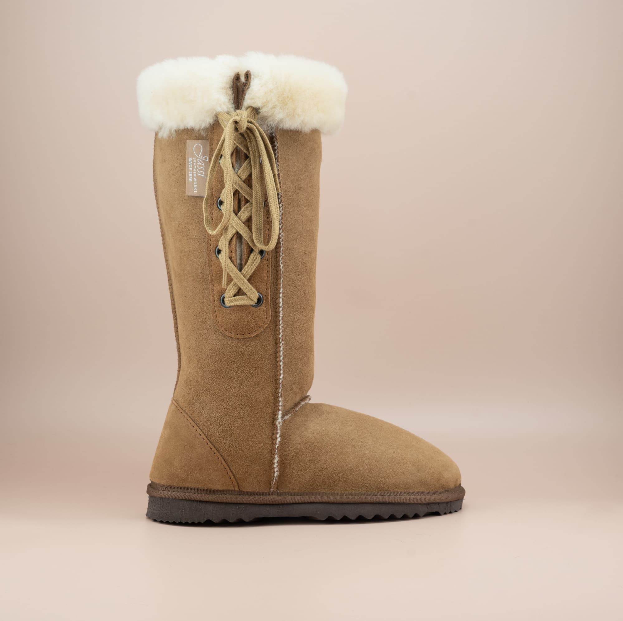 Men's long lace-up ugg boot in color tan and soft suede finish with signature wool turn, side view. #color_tan