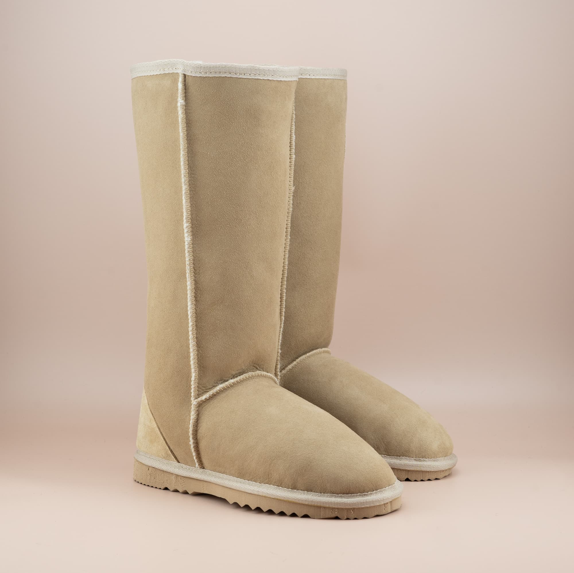 Men's long ugg boot in color sand and soft suede finish, front side view. #color_sand