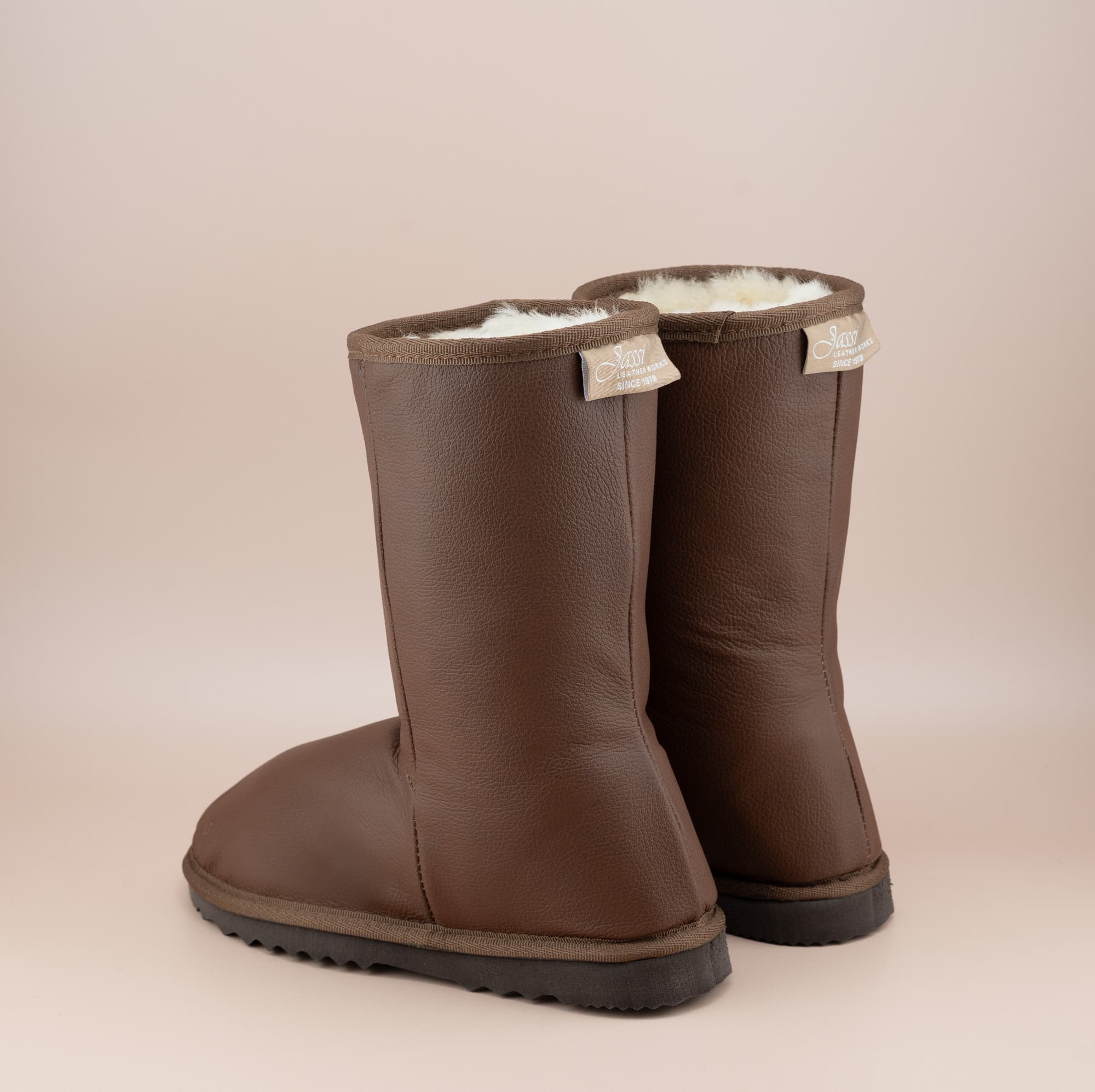 Men's Classic Mid ugg boots in genuine leather finish and tan color, back view. #color_leather tan