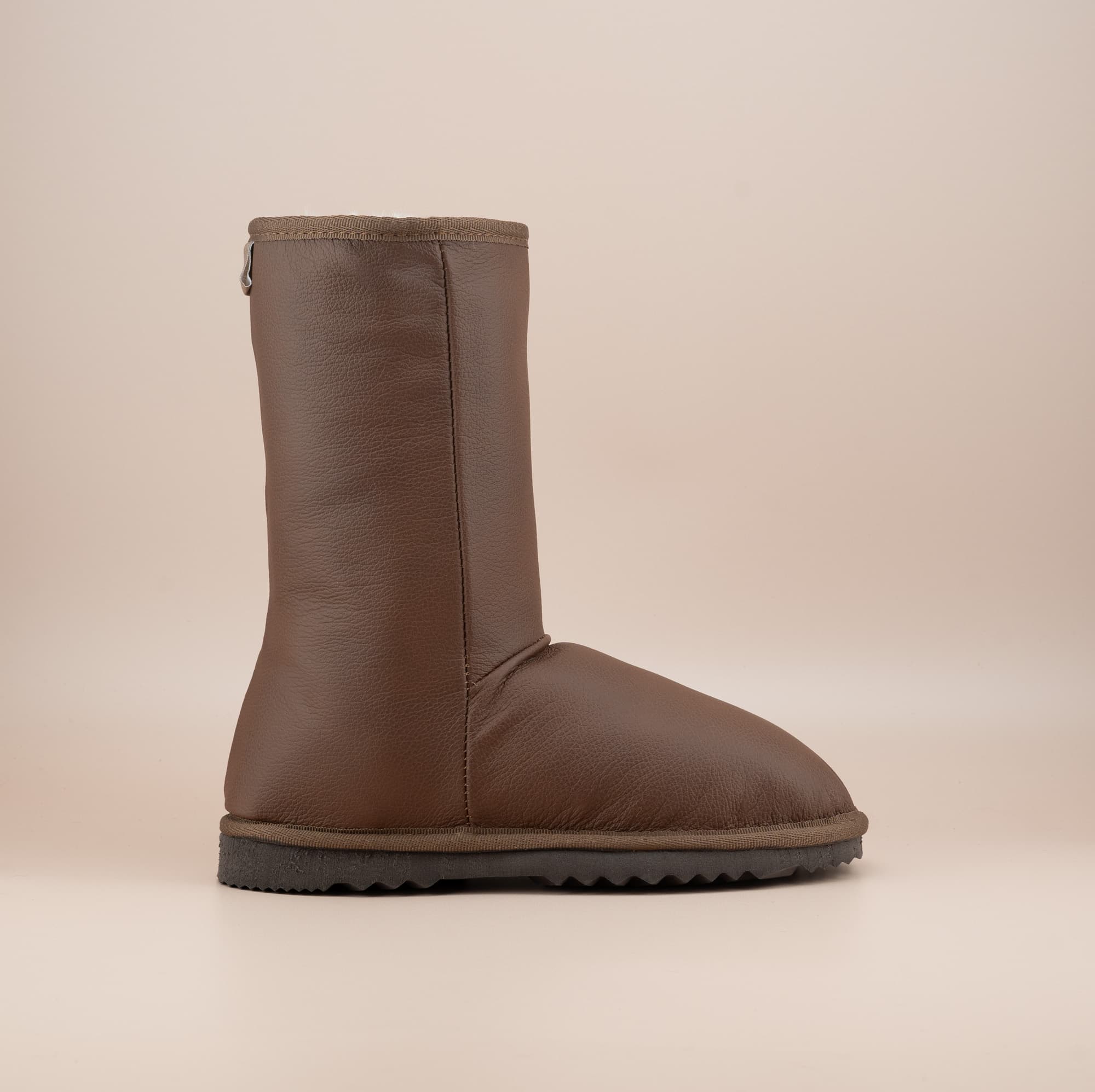 Men's Classic Mid ugg boots in genuine leather finish and tan color, side view. #color_leather tan