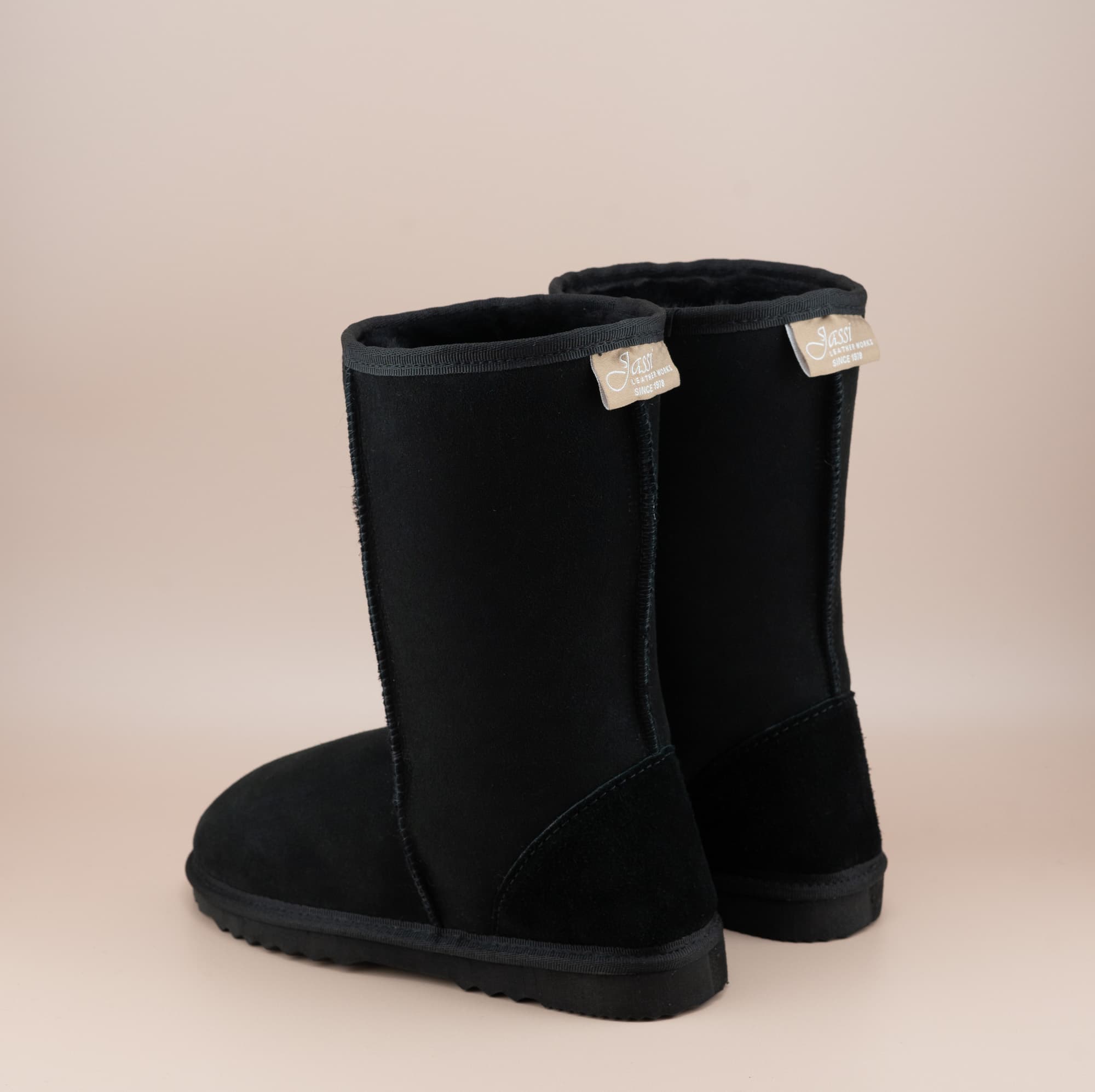 Men's mid ugg boot in color black and soft suede finish, back view. #color_black