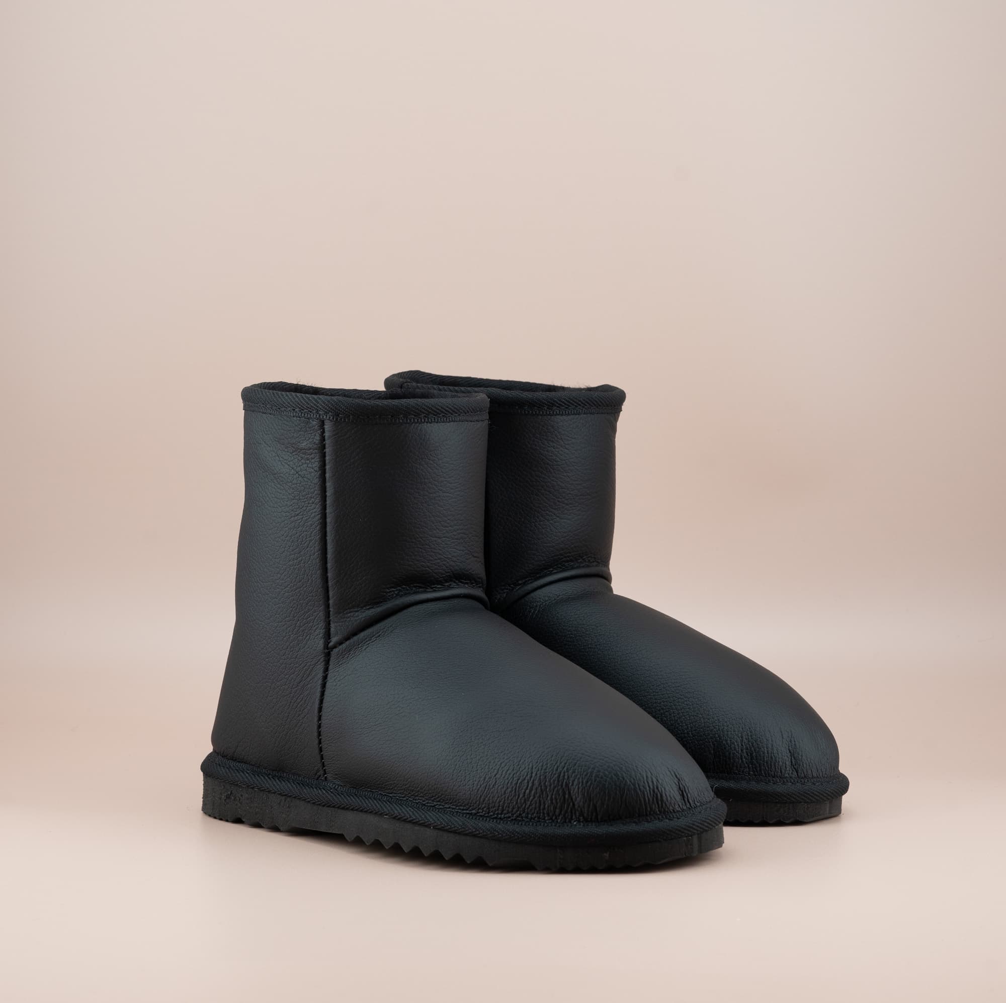 Men's Classic Short ugg boots in genuine leather finish and black color, front side view. #color_leather black