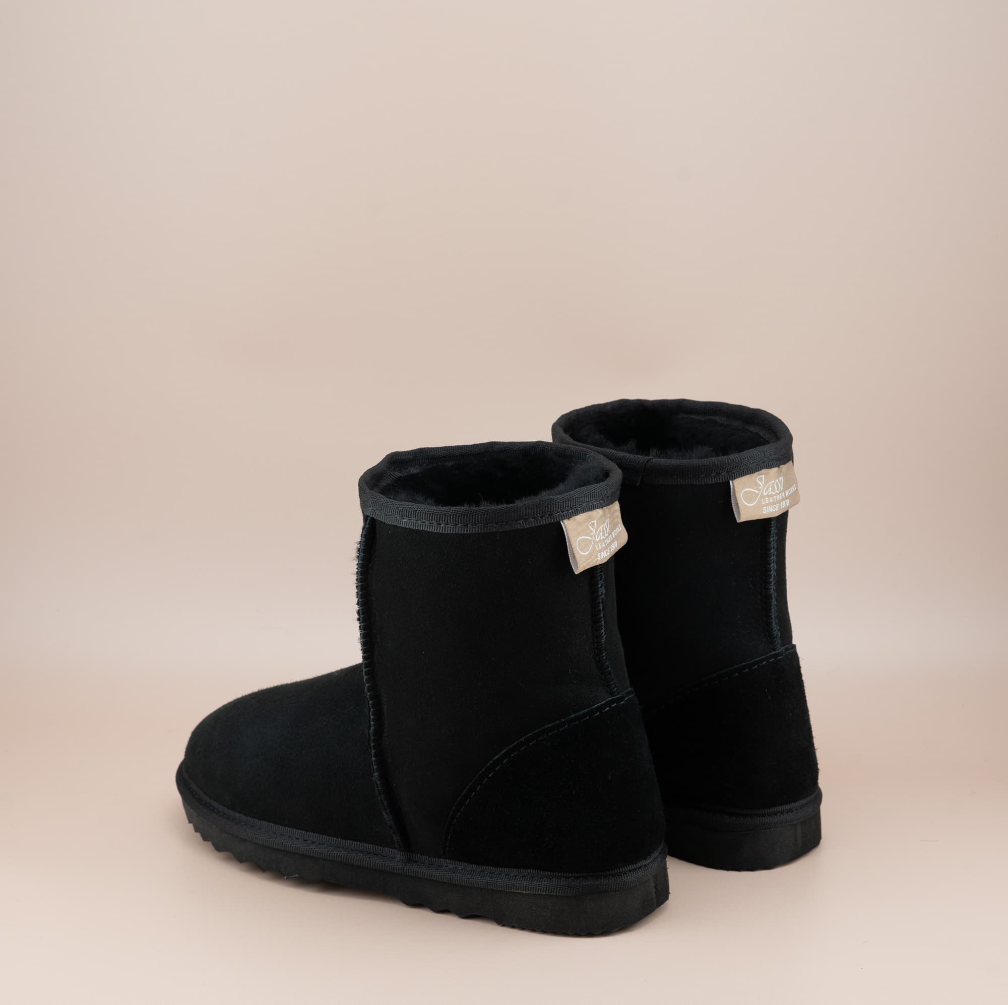 Men's short ugg boot in color black and soft suede finish, back view. #color_black