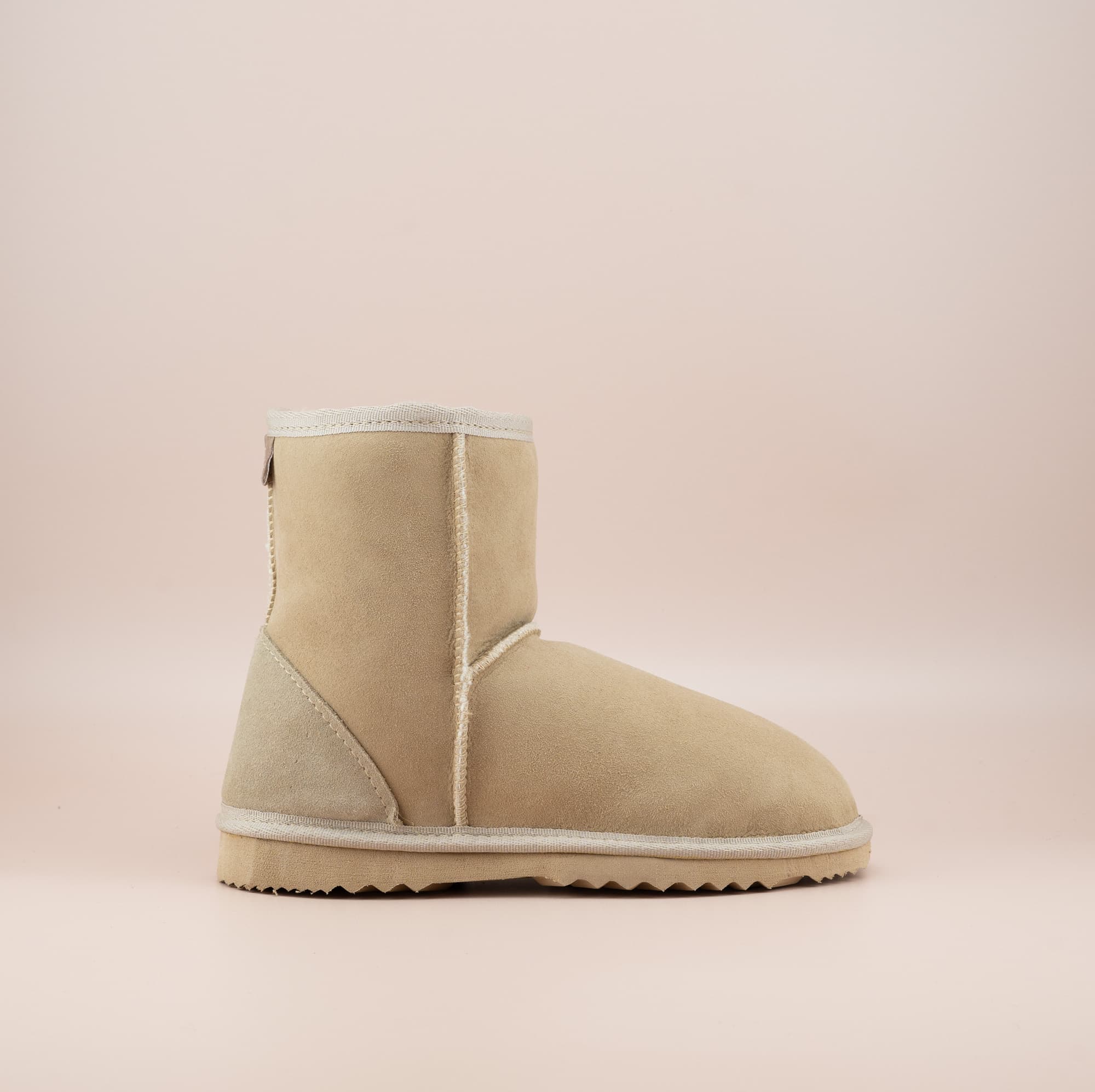 Men's short ugg boot in a sand color and soft suede finish, side view. #color_sand