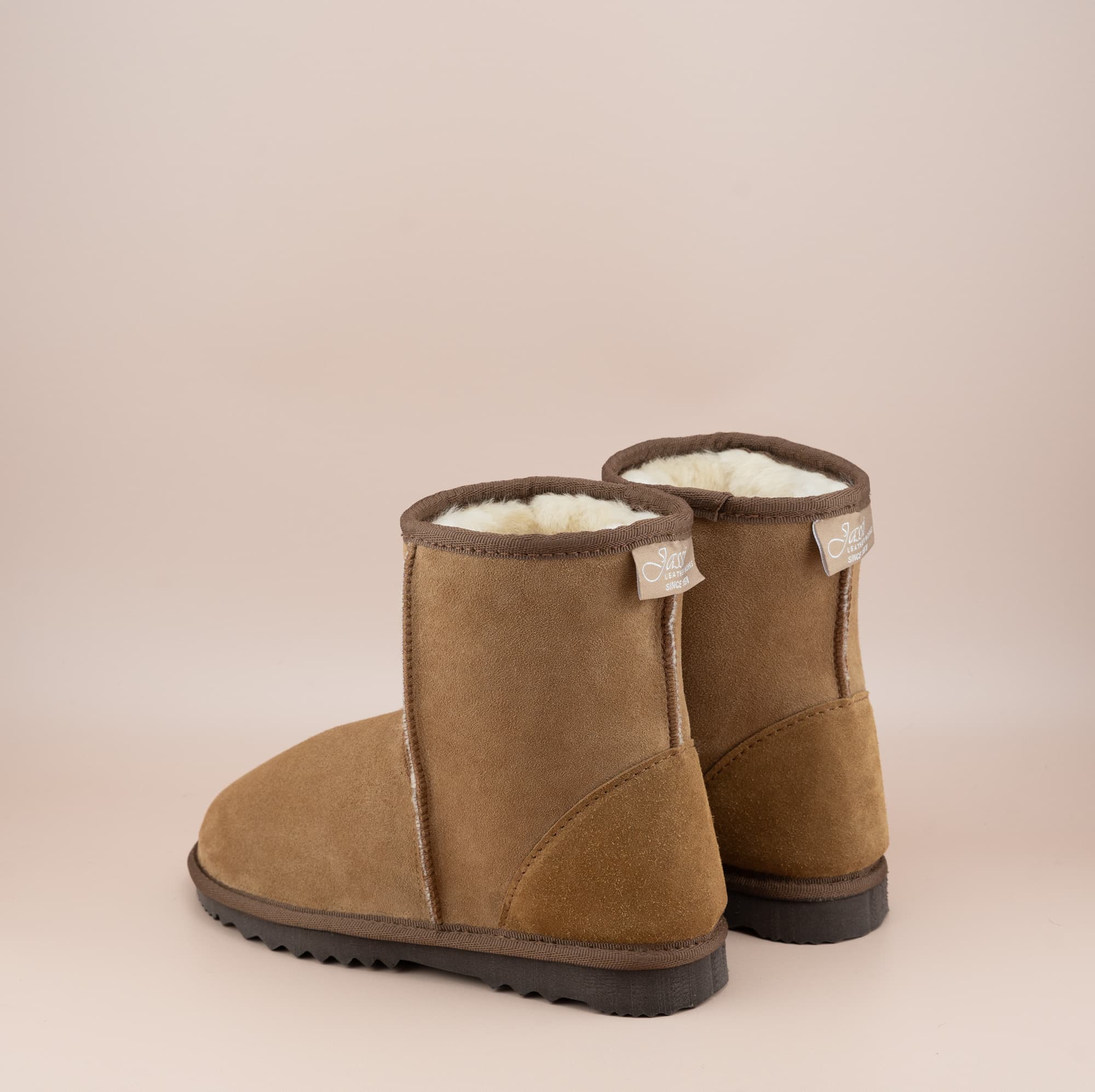 Men's short ugg boot in tan color and soft suede finish, back view. #color_tan