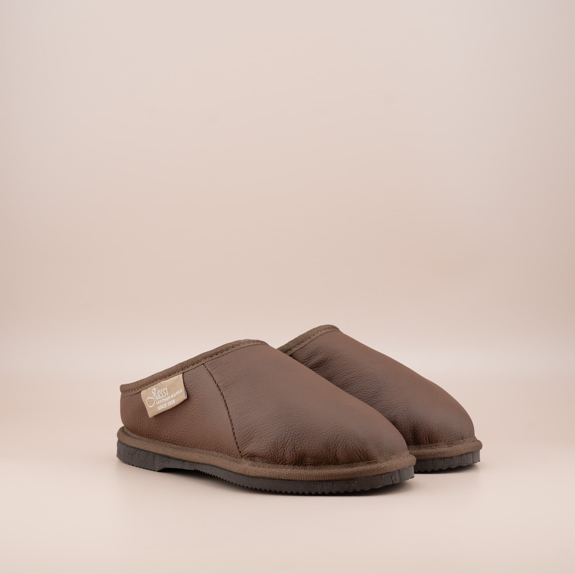 Men's ugg mewels with a leather finish in tan, front side view. #color_leather tan