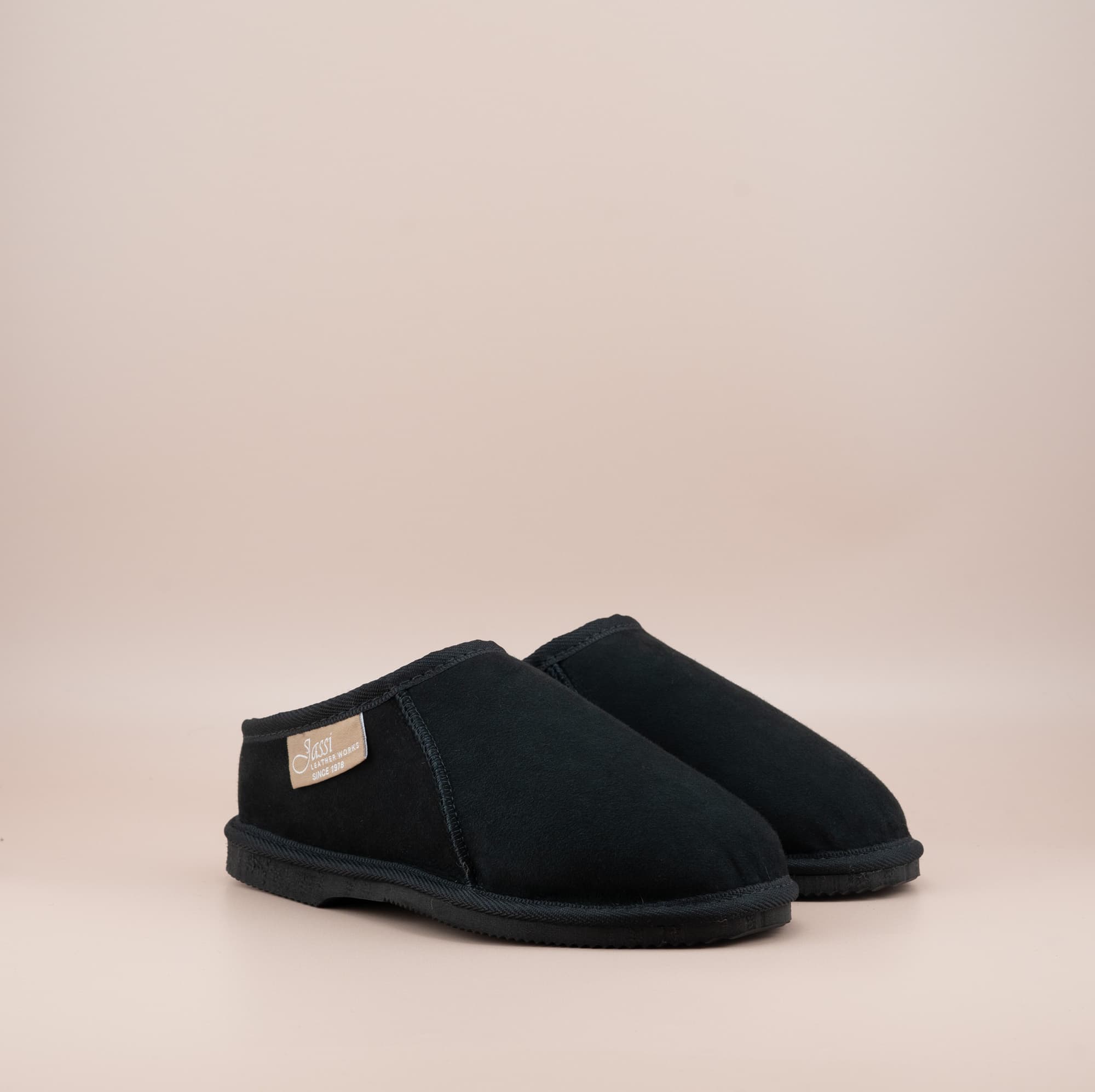 Men's ugg mewels with a suede finish in black, front side view. #color_black