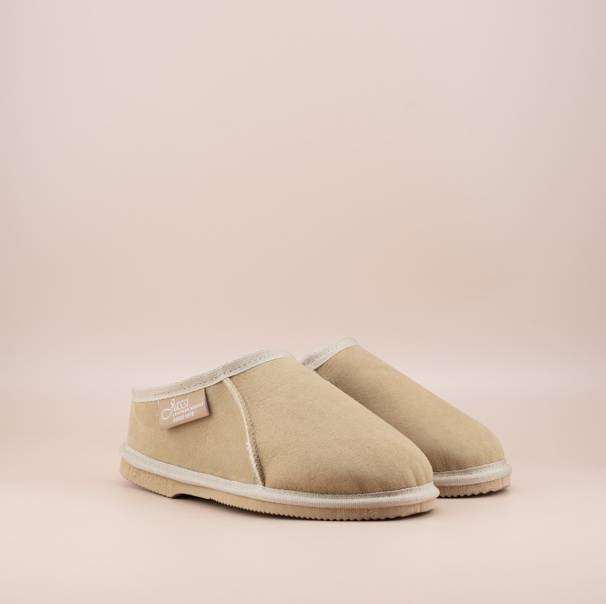 Men's ugg mewels with a suede finish in sand, front side view. #color_sand