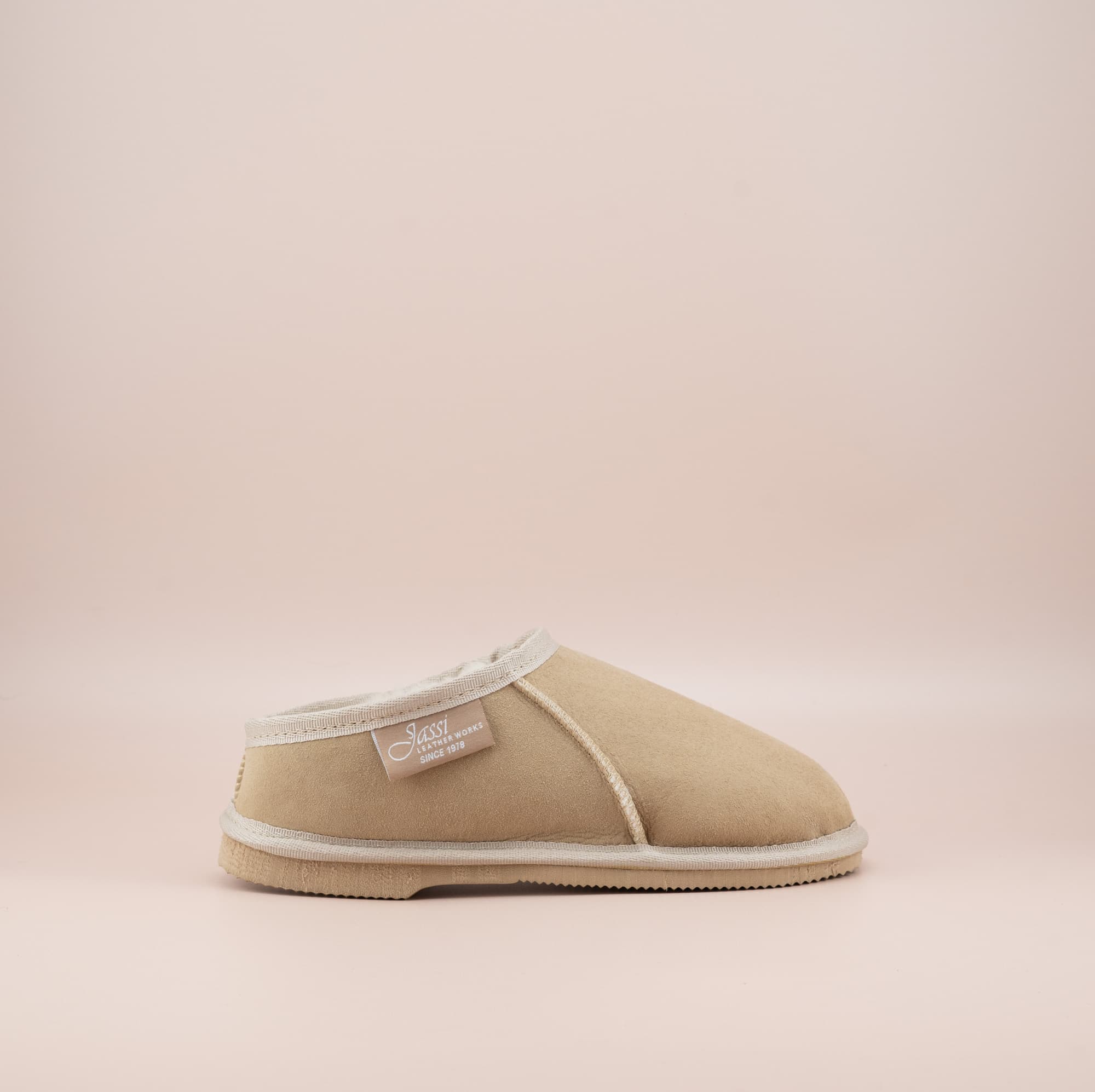 Men's ugg mewels with a suede finish in sand, side view. #color_sand