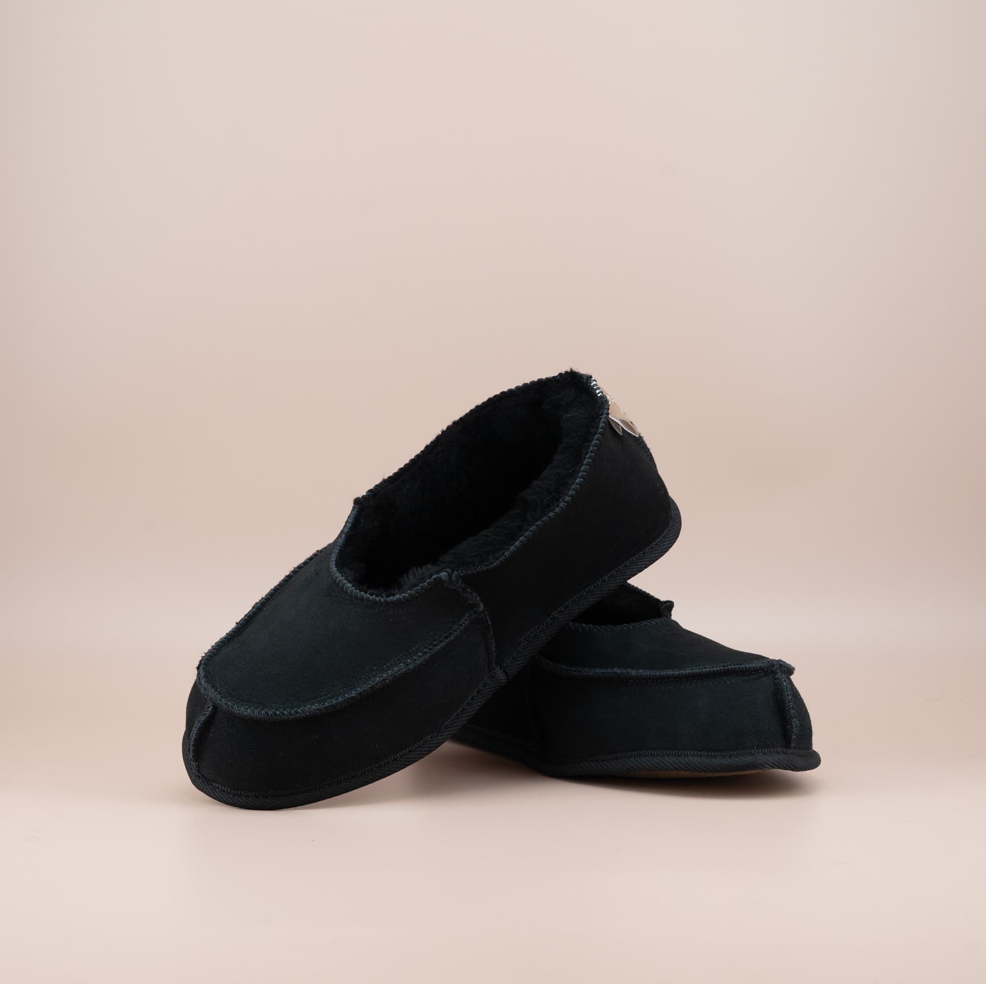 Men's ugg moccasins with a suede finish in black, front and side view. #color_black