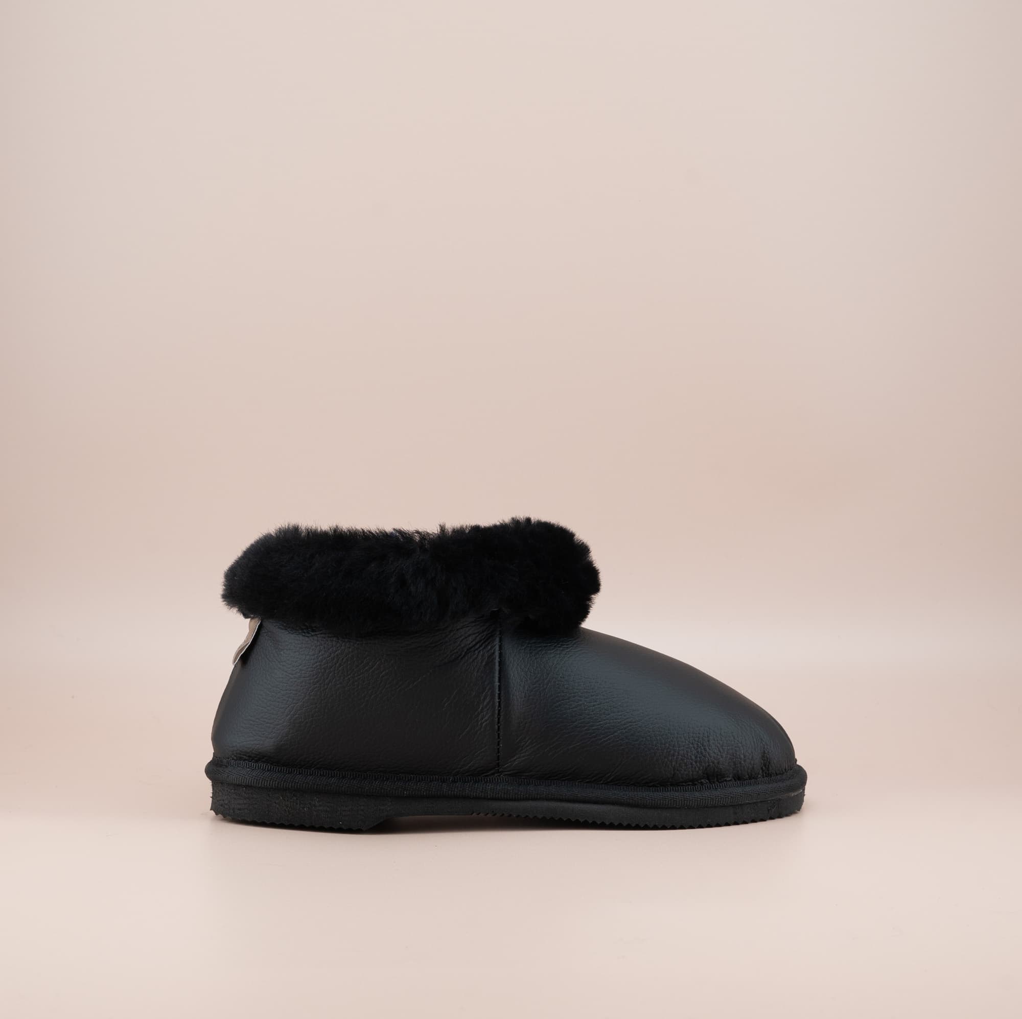 Men's ugg slippers with a genuine leather finish in black and wool turn, single side view #color_leather black