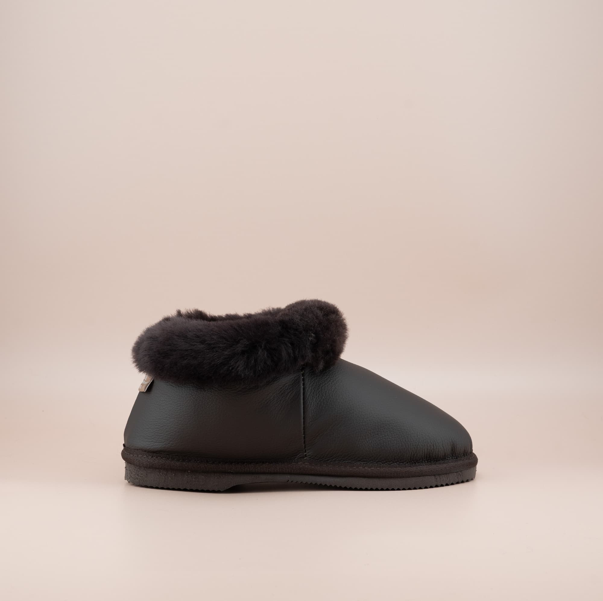 Men's ugg slippers with a genuine leather finish in chocolate and wool turn, single side view. #color_leather chocolate