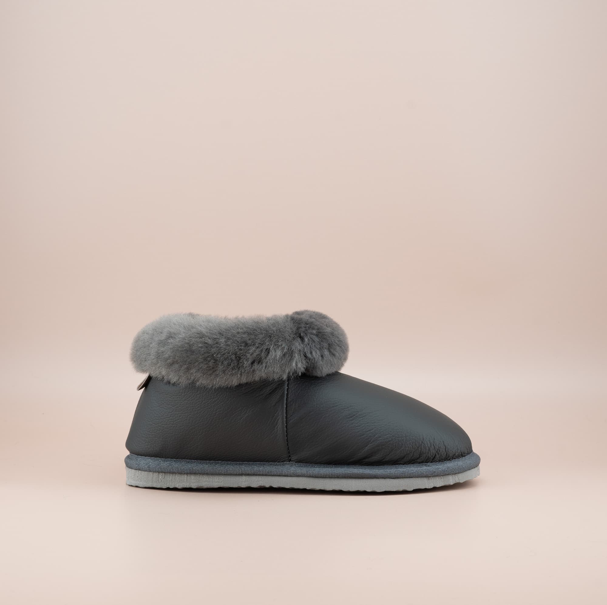 Men's ugg slippers with a genuine leather finish in grey and wool turn, single side view. #color_leather grey