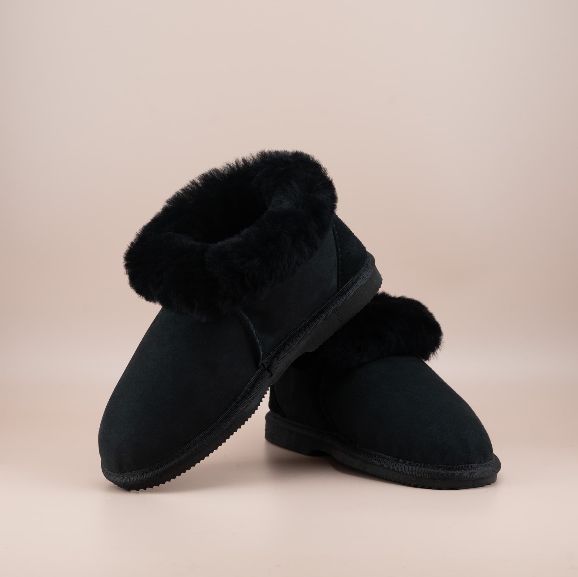 Men's ugg slippers with a suede finish in black and wool turn, front and side view. #color_black