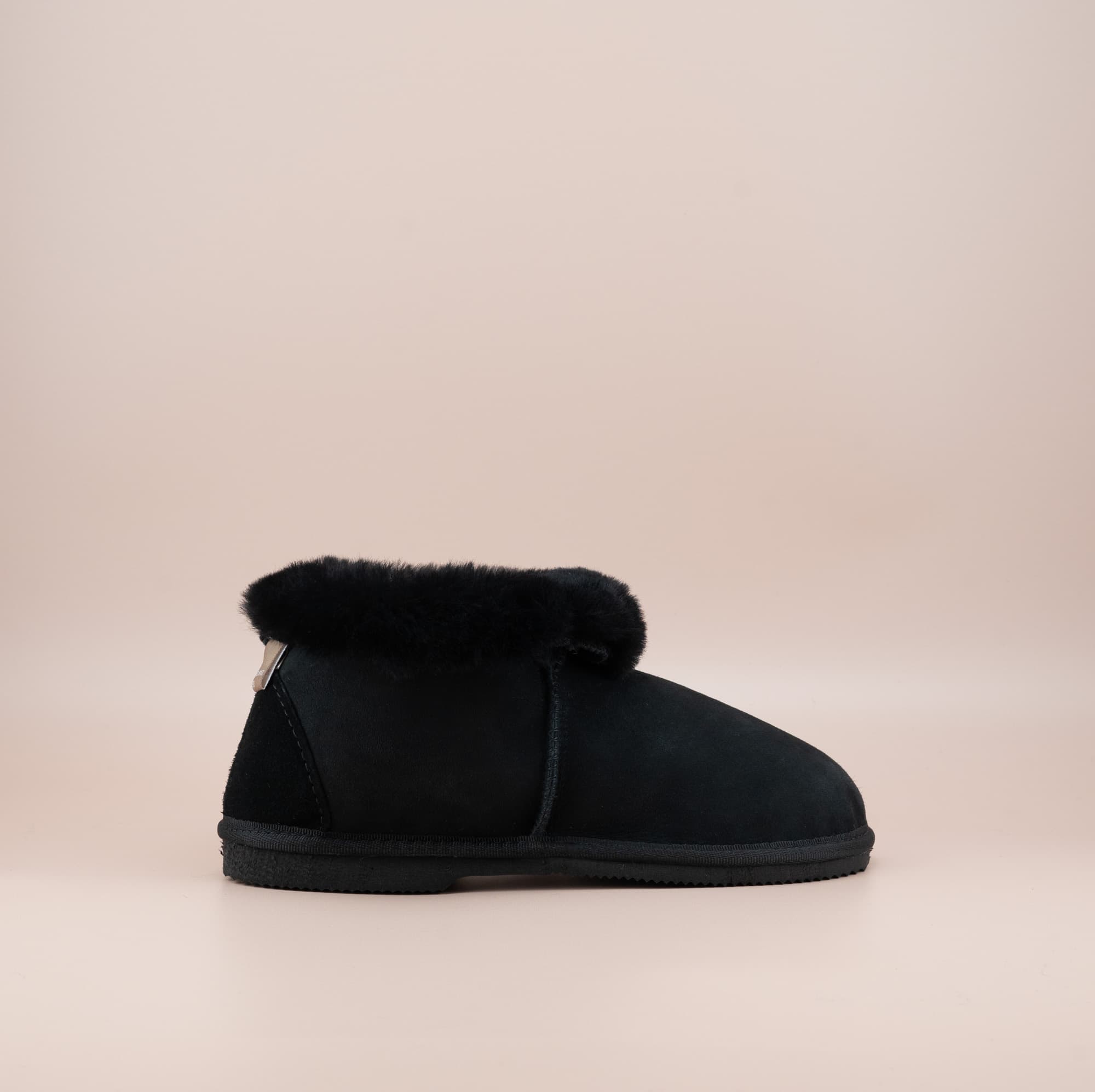 Men's ugg slippers with a suede finish in black and wool turn, side view. #color_black