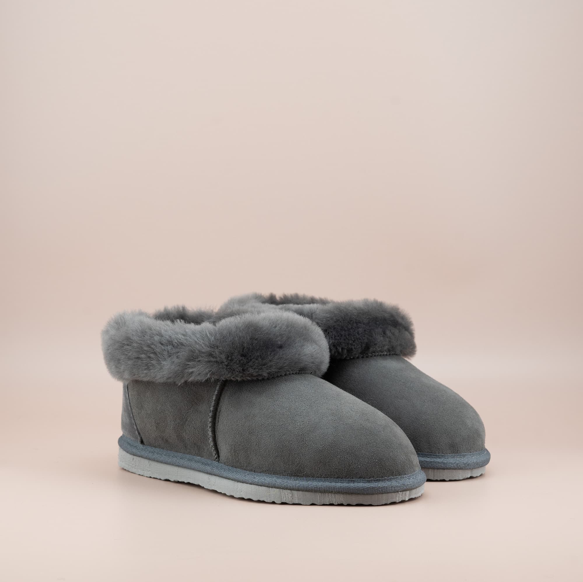 Men's ugg slippers with a suede finish in grey and wool turn, side view of the pair. #color_grey