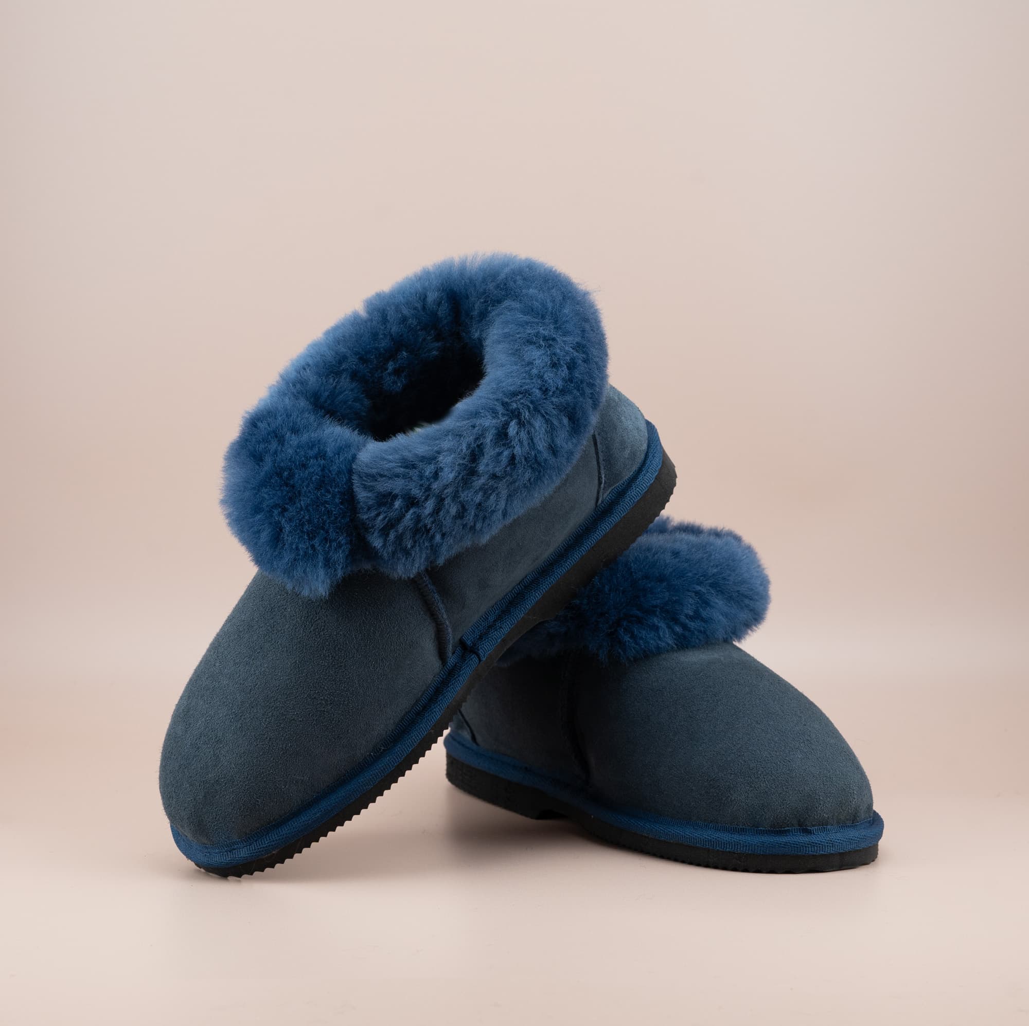 Men's ugg slippers with a suede finish in navy and wool turn, front and side view. #color_navy