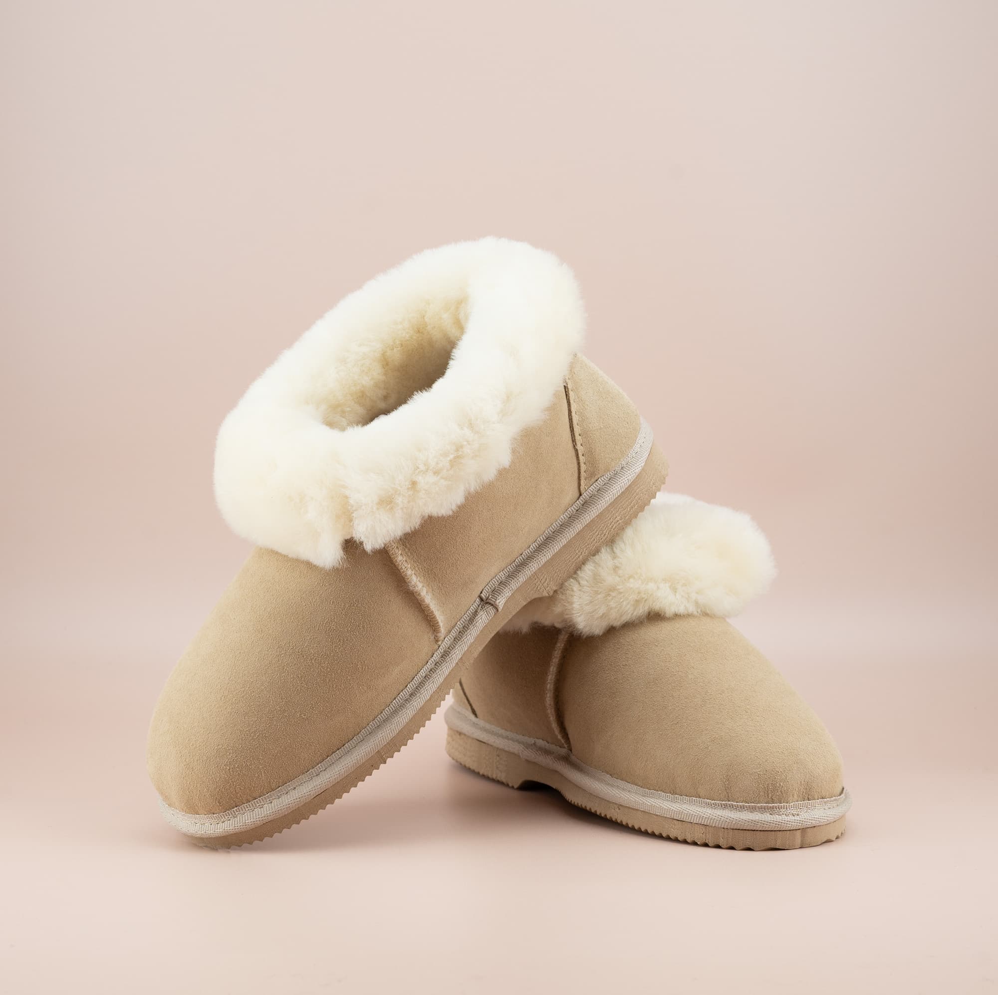 Men's ugg slippers with a suede finish in sand and wool turn, front and side view of the pair. #color_sand