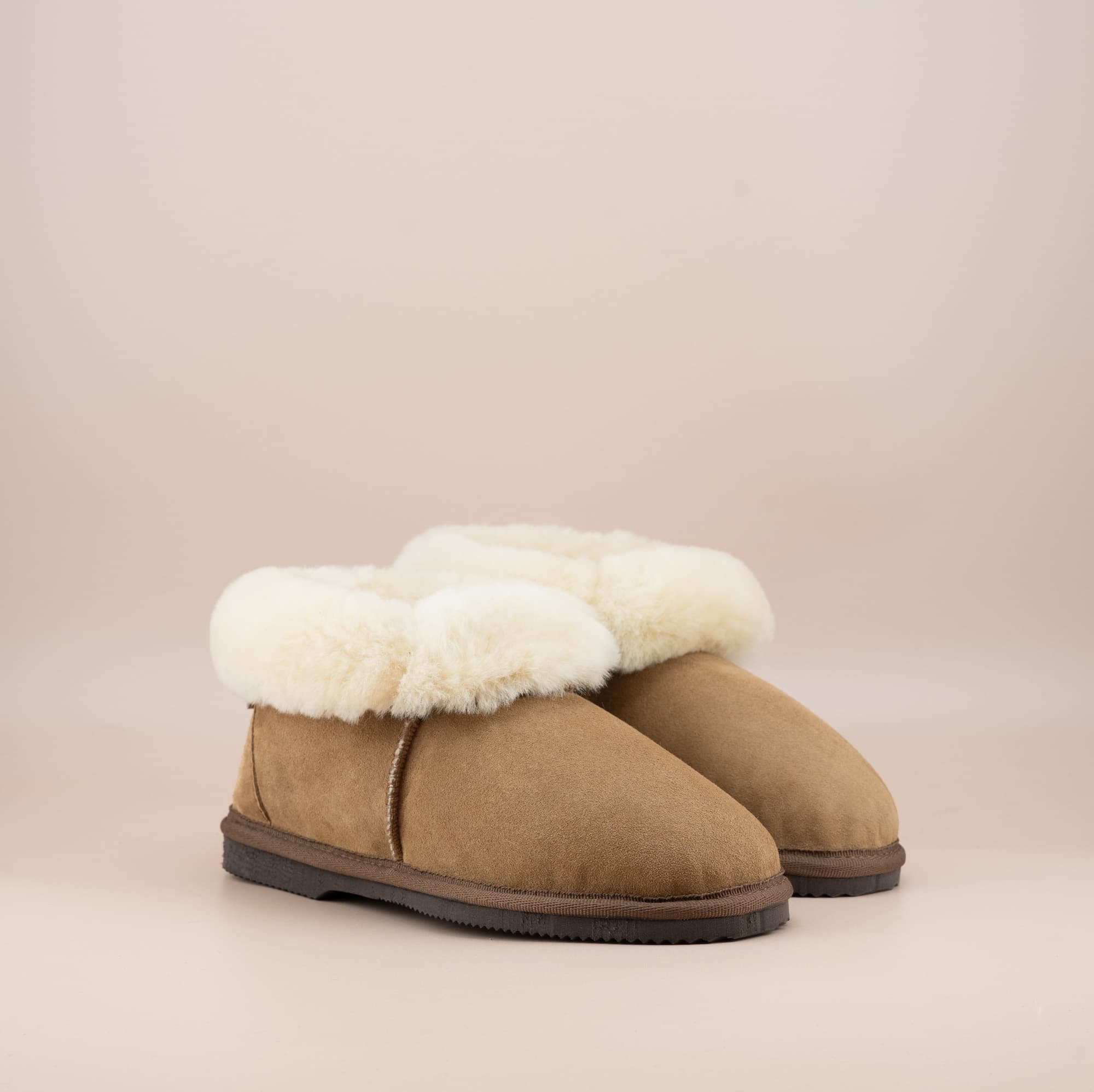 Men's ugg slippers with a suede finish in tan and wool turn, side view of the pair. #color_tan