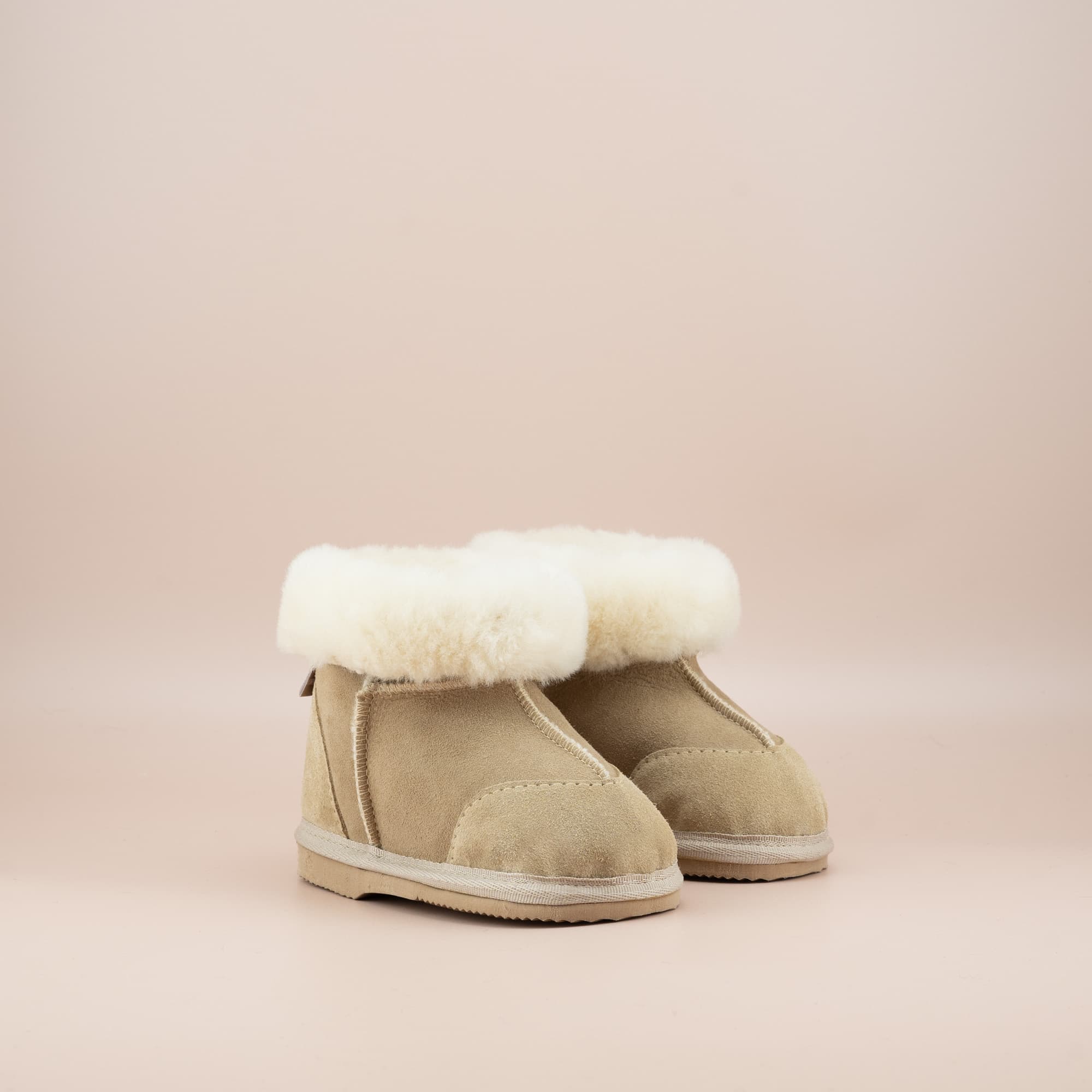 Toddler's ugg boots in soft suede sand with wool turn, front side view. #color_sand