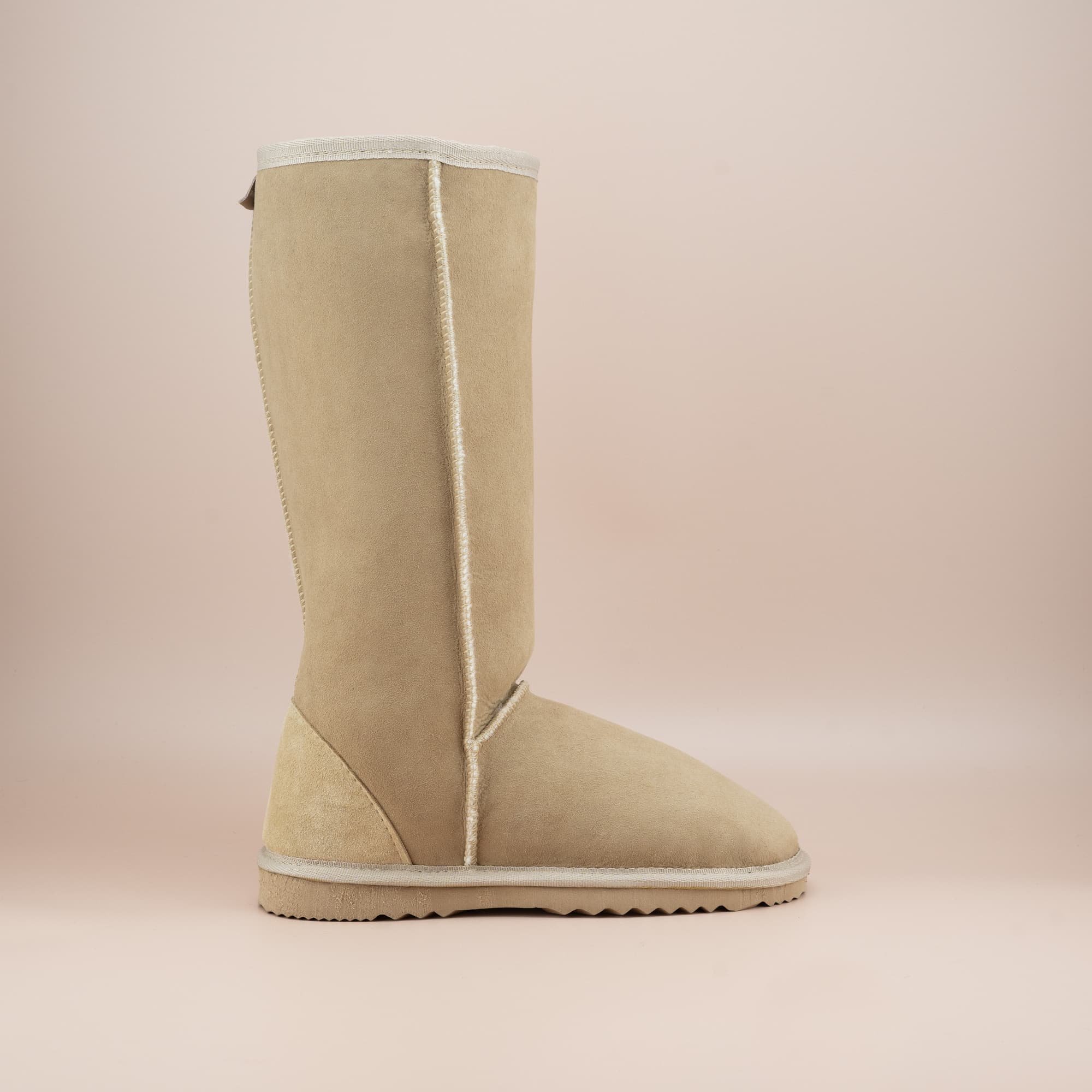 Women's classic long ugg boot in suede sand color, side view. #color_sand