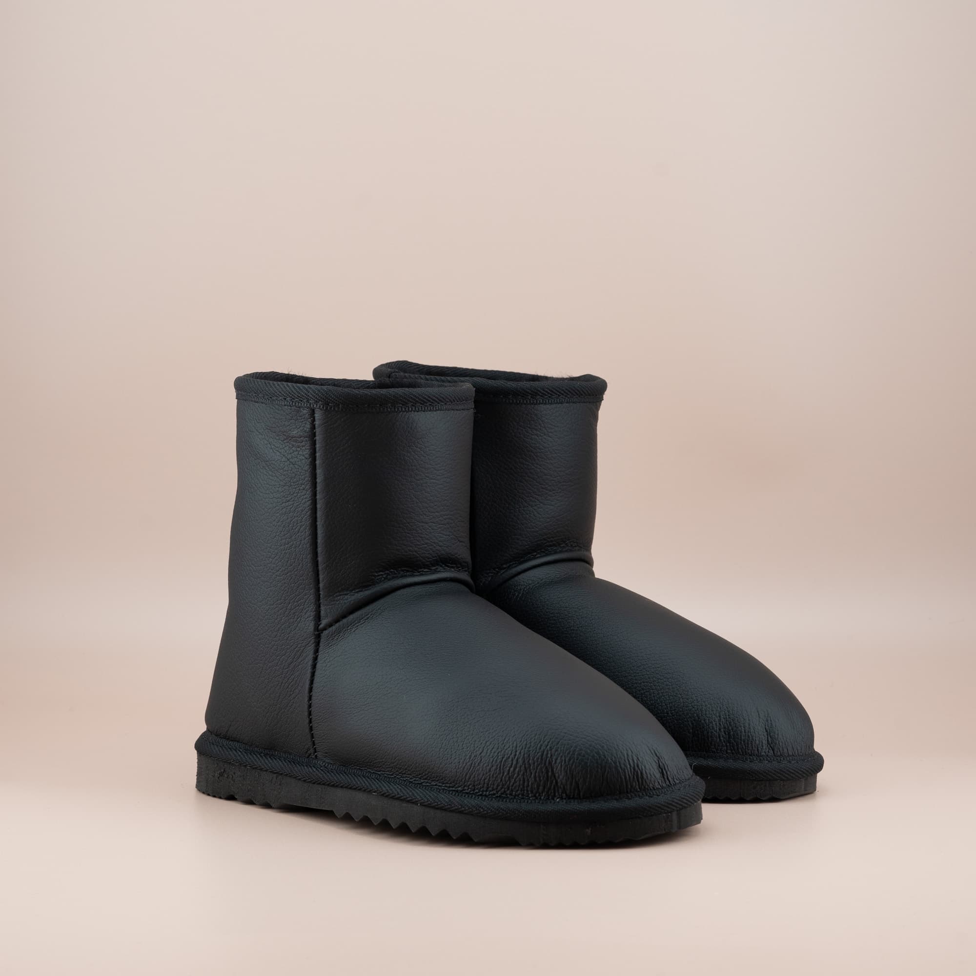 Women's classic short ugg boots in black leather, front side view. #color_leather black