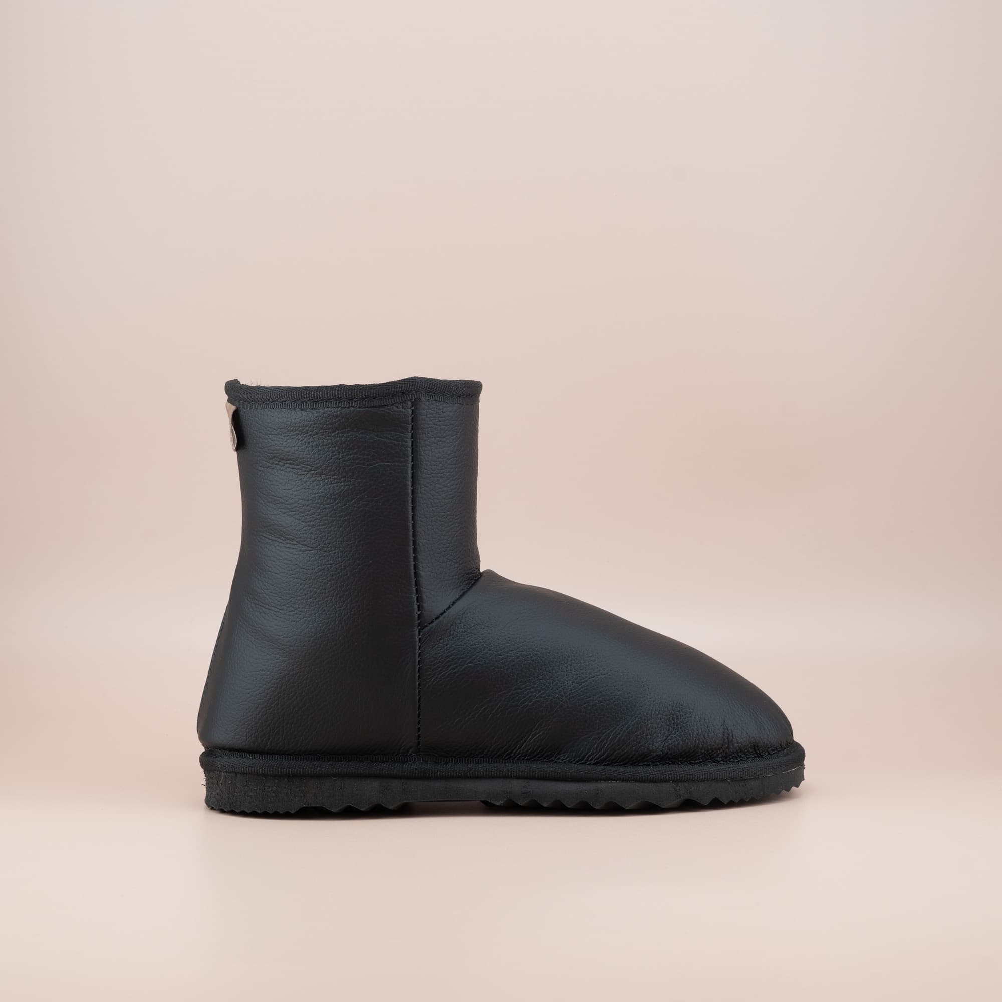 Women's classic short ugg boots in black leather, side view. #color_leather black