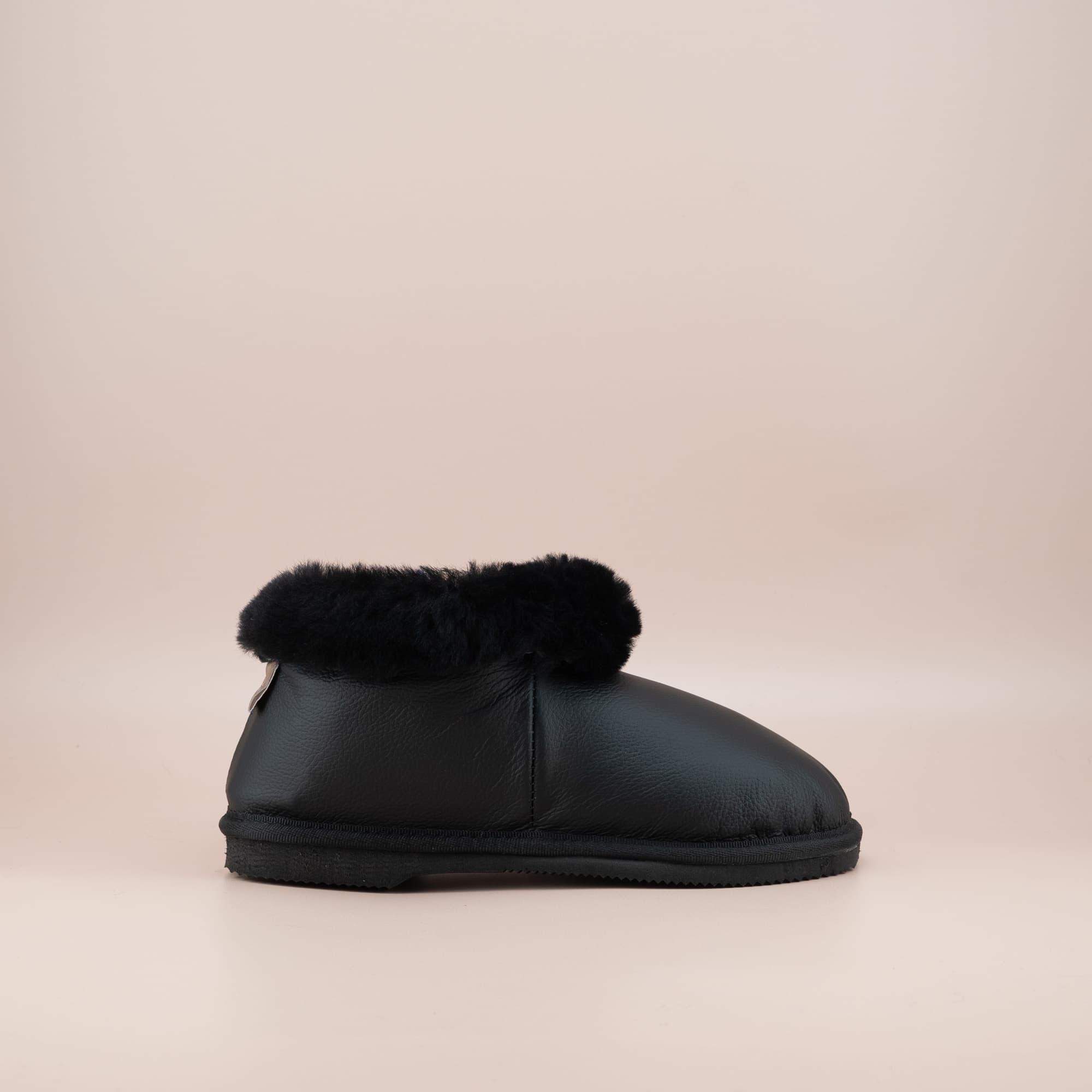 Women's ugg slippers in leather black and a soft wool turn, single side view. #color_leather black