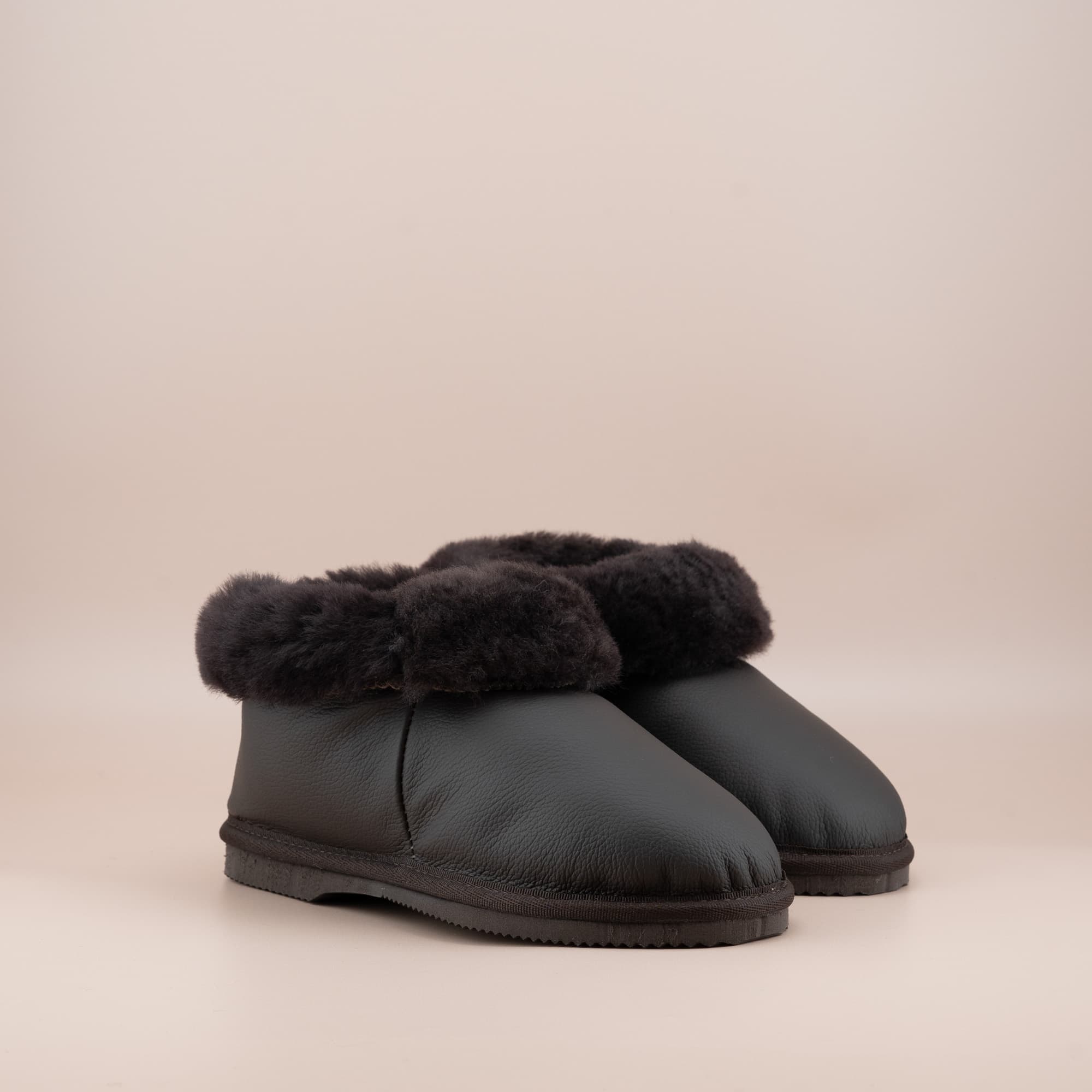 Women's ugg slippers in leather chocolate and a soft wool turn, side view of the pair. #color_leather chocolate